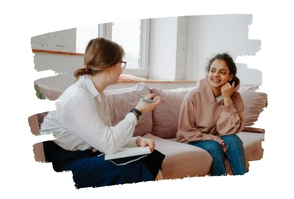 Kobieta rozmawia z dziewczynką na kanapie