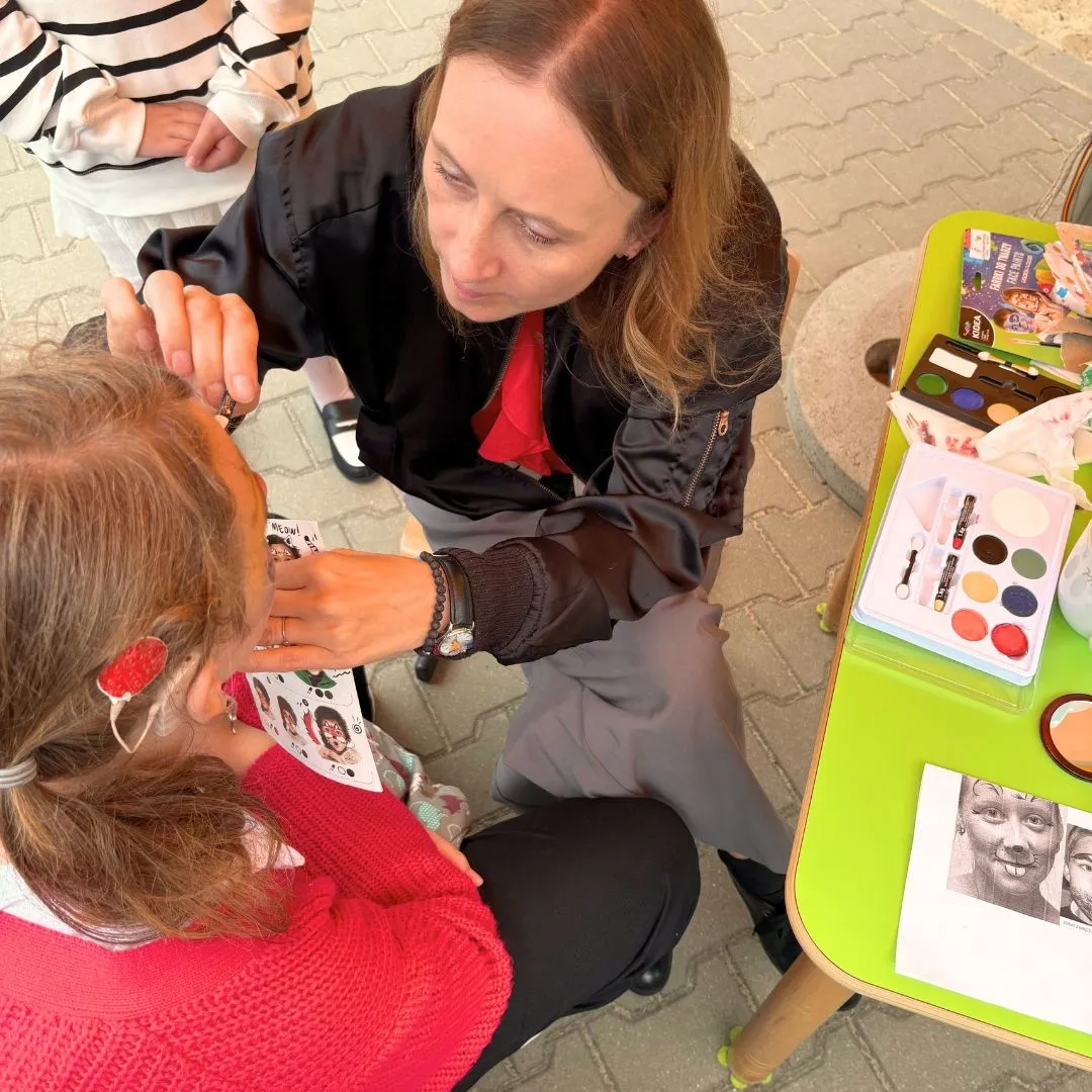 Stanowisko malowania twarzy - nauczyciel maluje twarz uczennicy