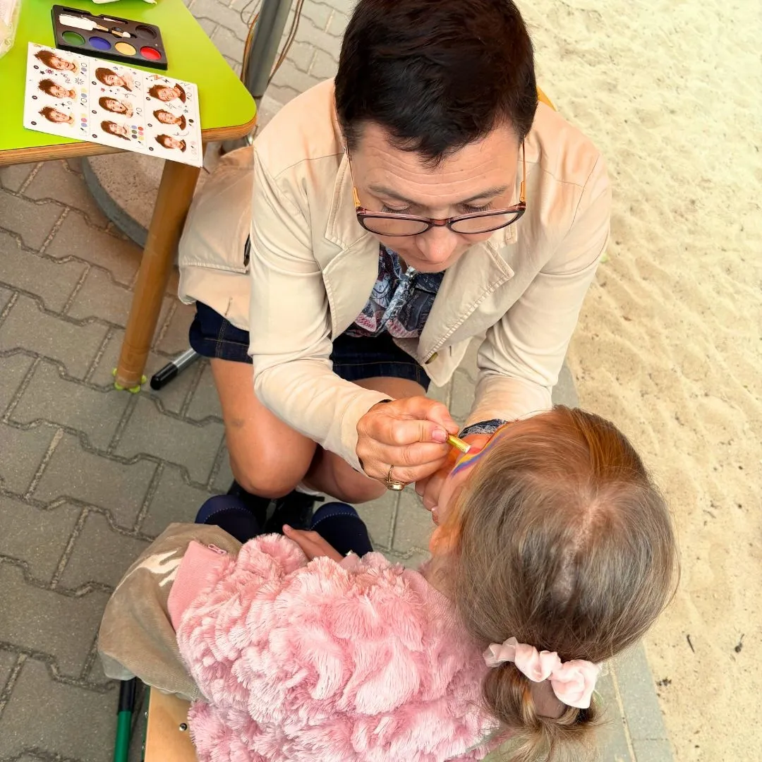 Stanowisko malowania twarzy - nauczyciel maluje twarz uczennicy