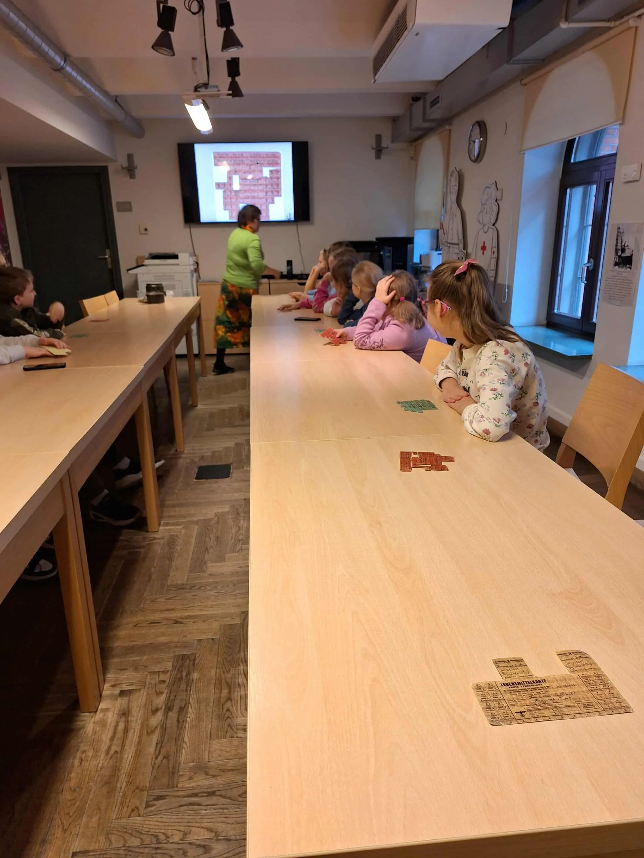 Uczniowie siedzący przy stołach podczas warsztatów