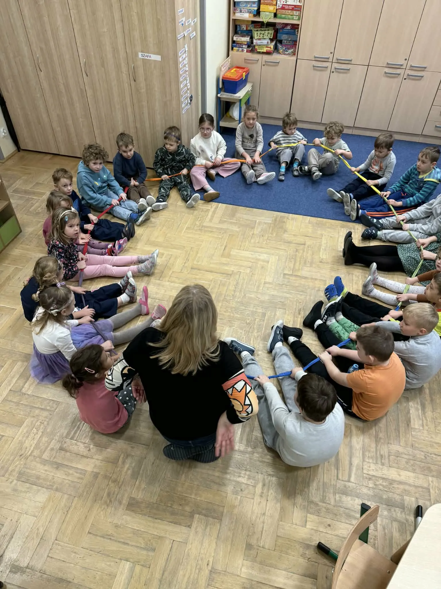 Przedszkolaki siedzące w kole