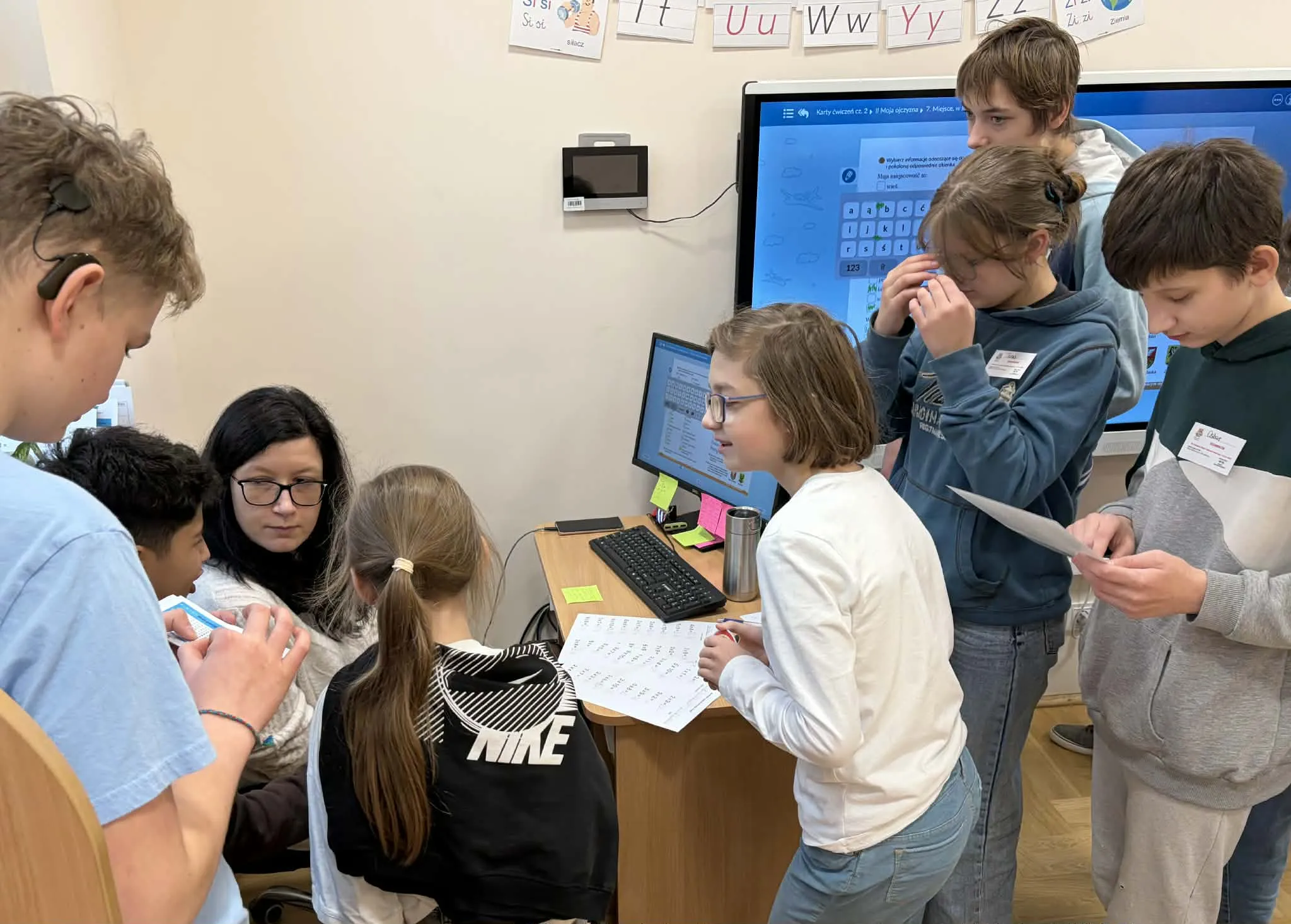 Delegacja uczniów sprawdzająca znajomość tabliczki uczniów wśród pracowników szkoły