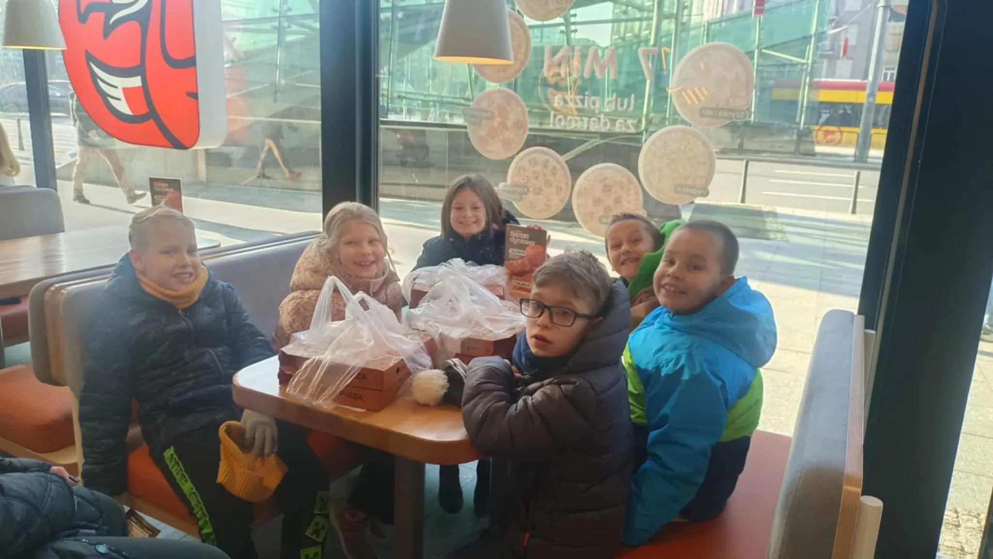 Uczniowie siedzący w pizzerii 