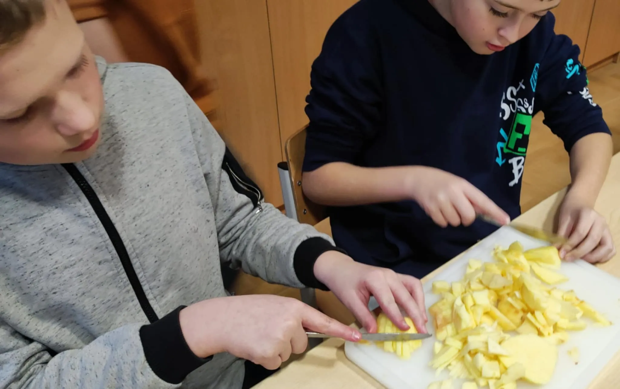 Uczniowie krojący owoce