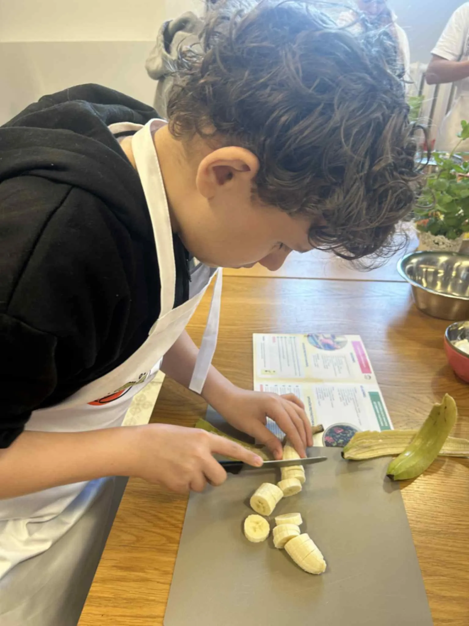 Uczeń krojący banana