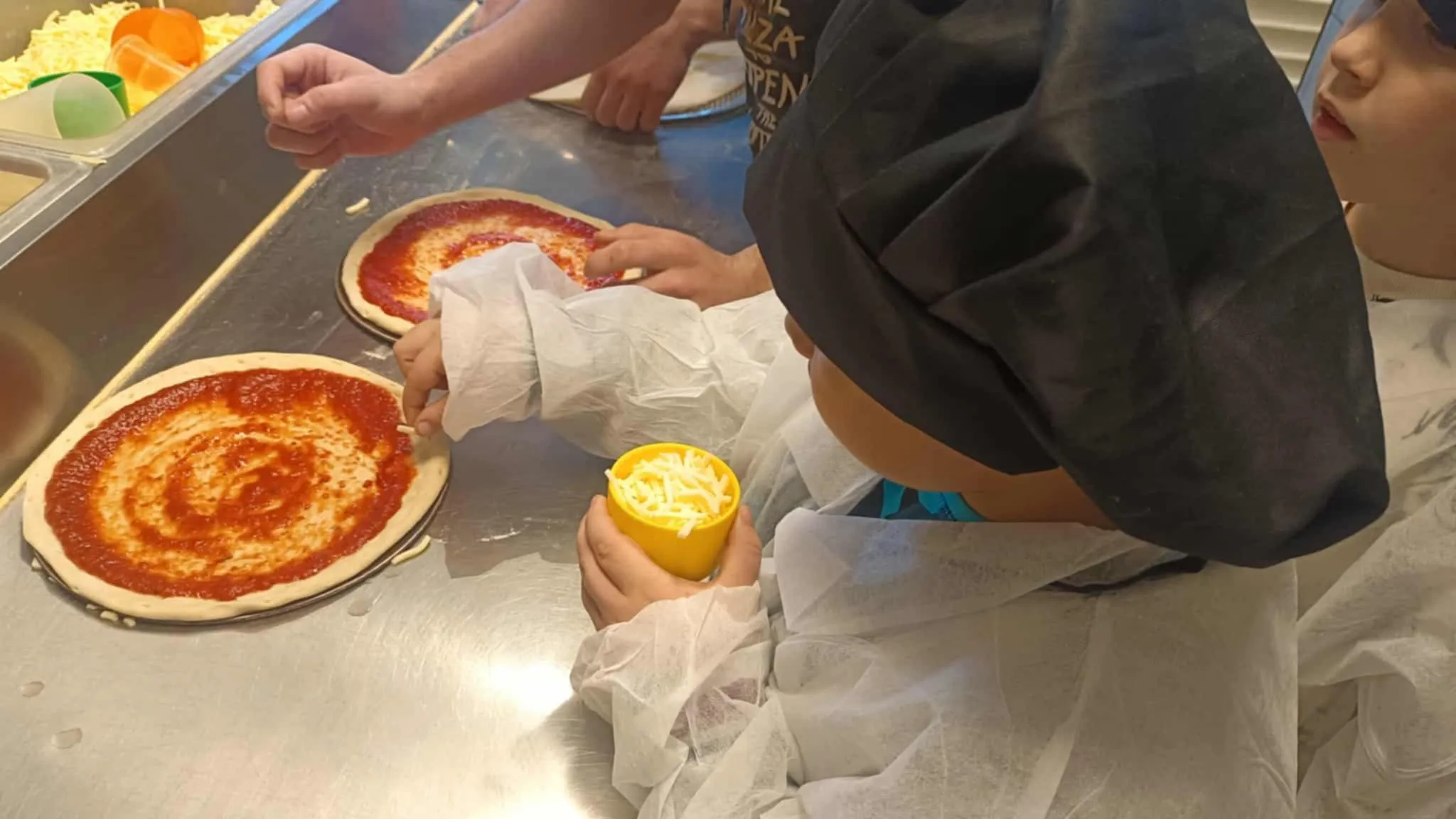 Uczeń sypiący ser na pizzę