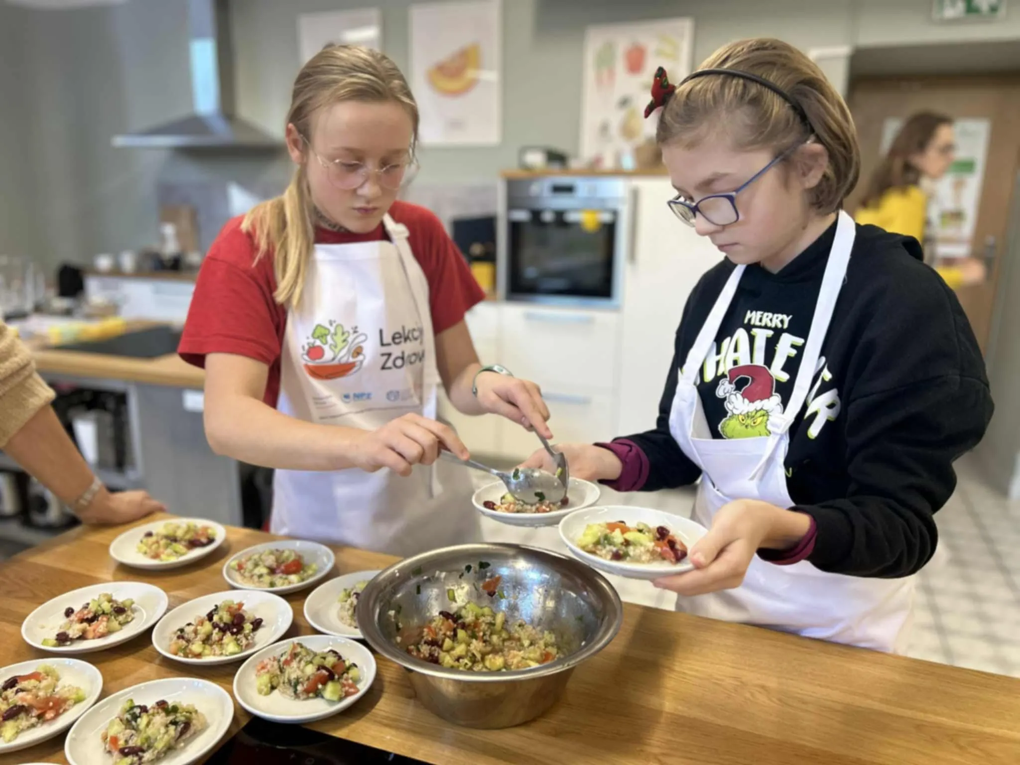 Uczennice nakładające sałatkę na talerze