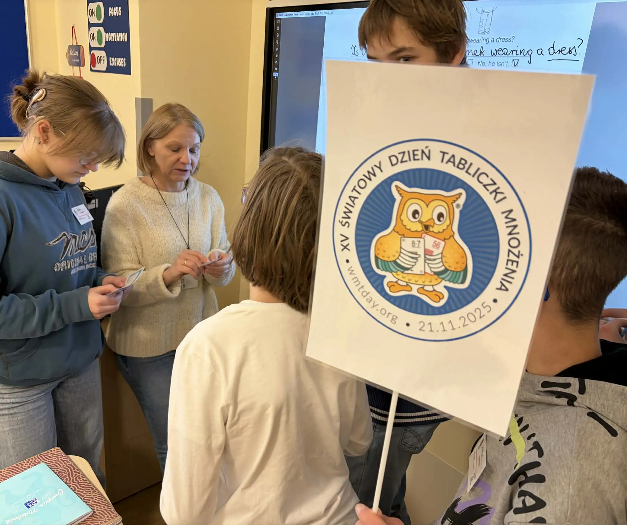 Delegacja uczniów sprawdzająca znajomość tabliczki uczniów wśród pracowników szkoły