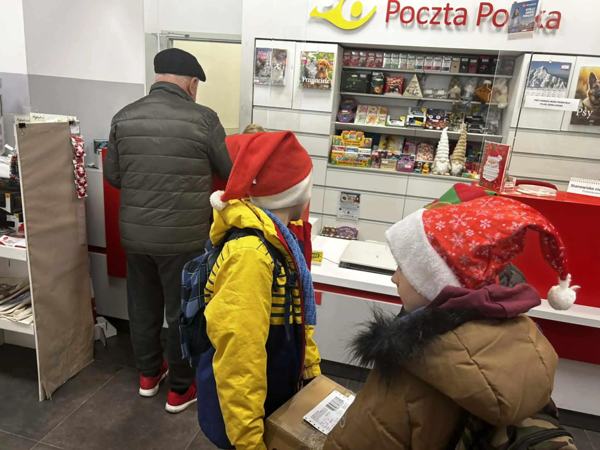 Uczniowie wysyłający paczkę na poczcie 