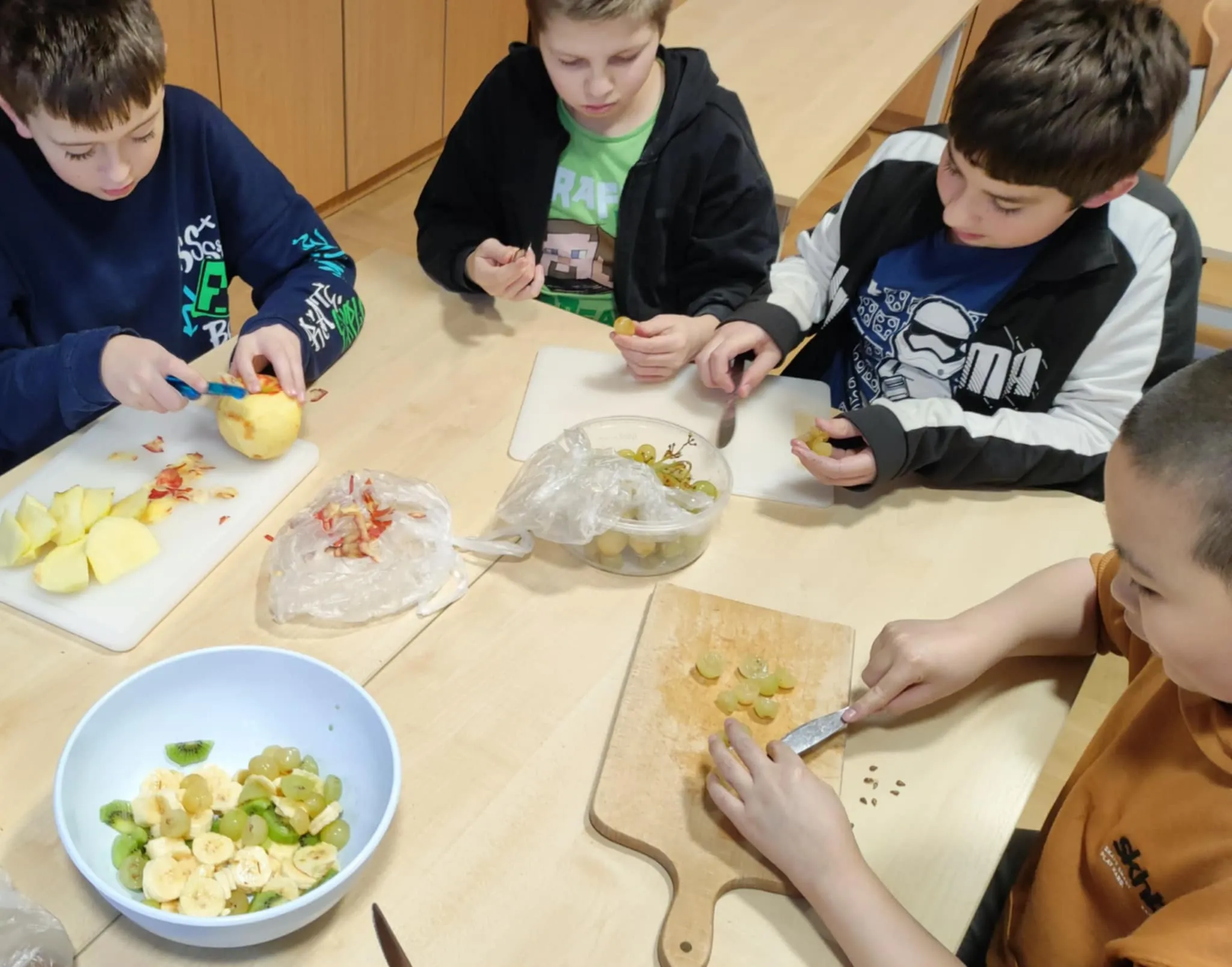 Uczniowie krojący owoce