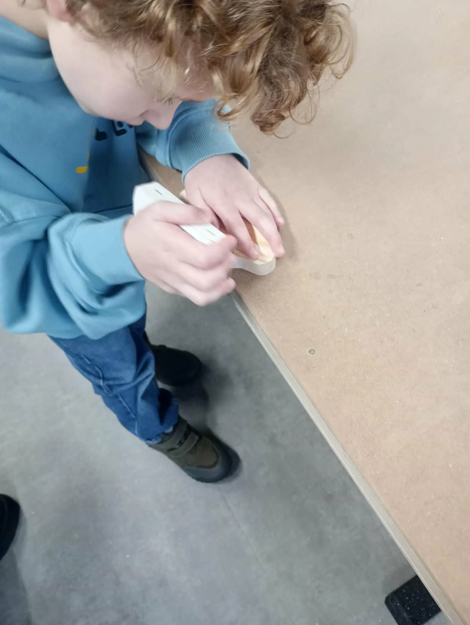 Szlifowanie pingwina z drewna przez dziecko 