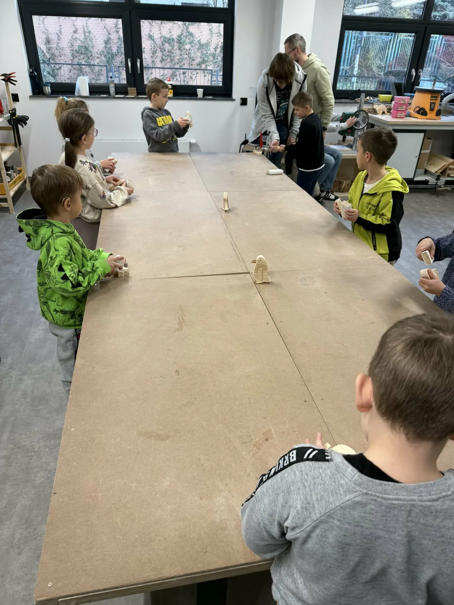 Przedszkolaki przy stole w stolarni