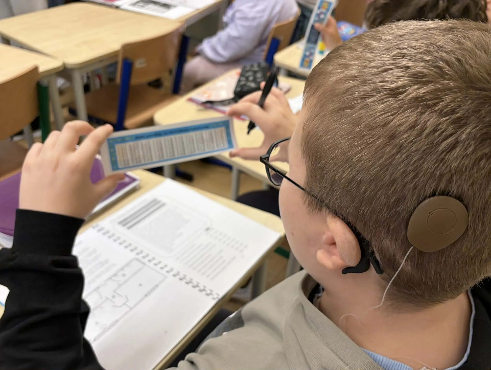 Uczeń trzymający w rękach tabliczkę mnożenia 