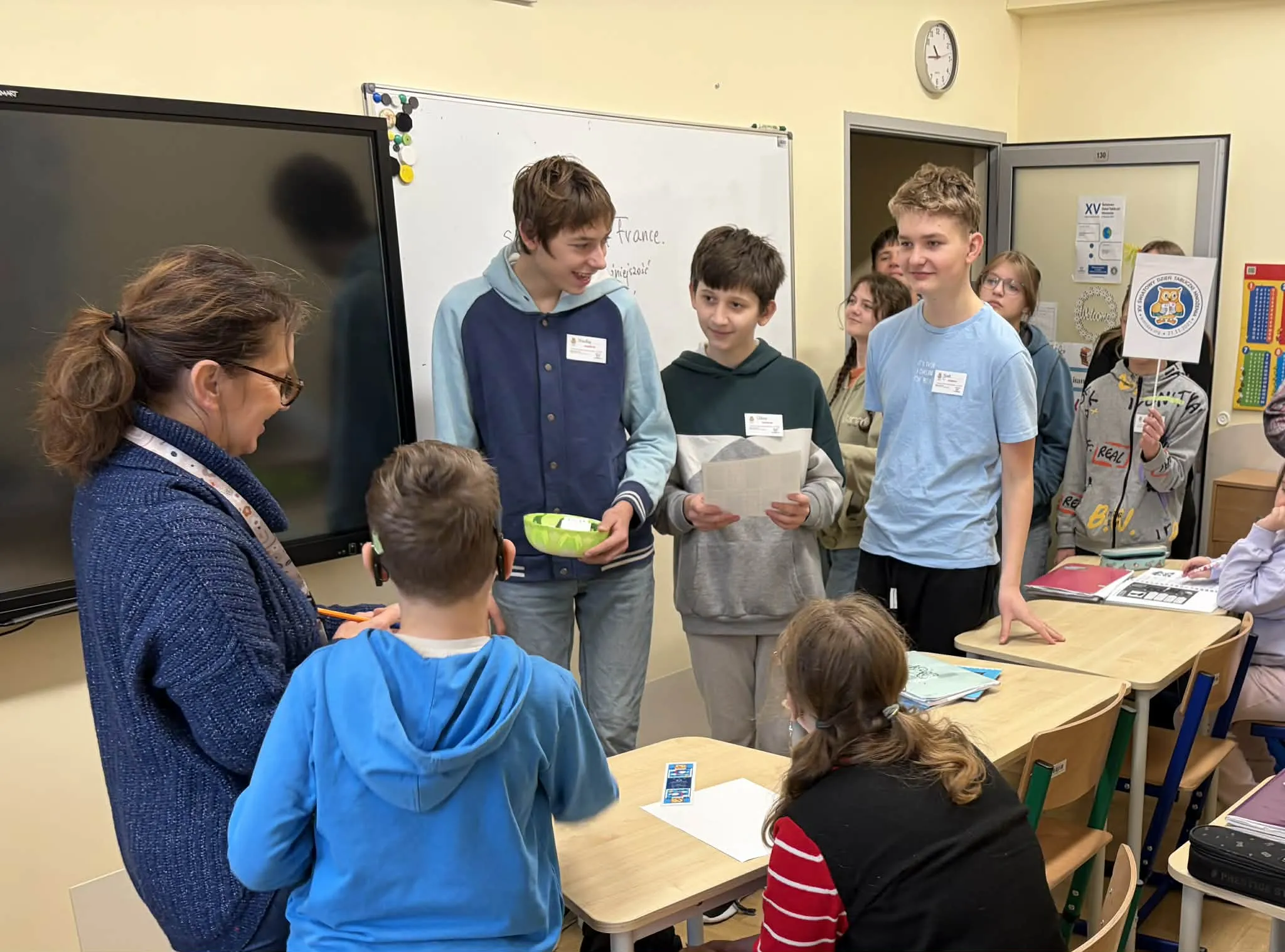 Delegacja uczniów sprawdzająca znajomość tabliczki uczniów wśród pracowników szkoły