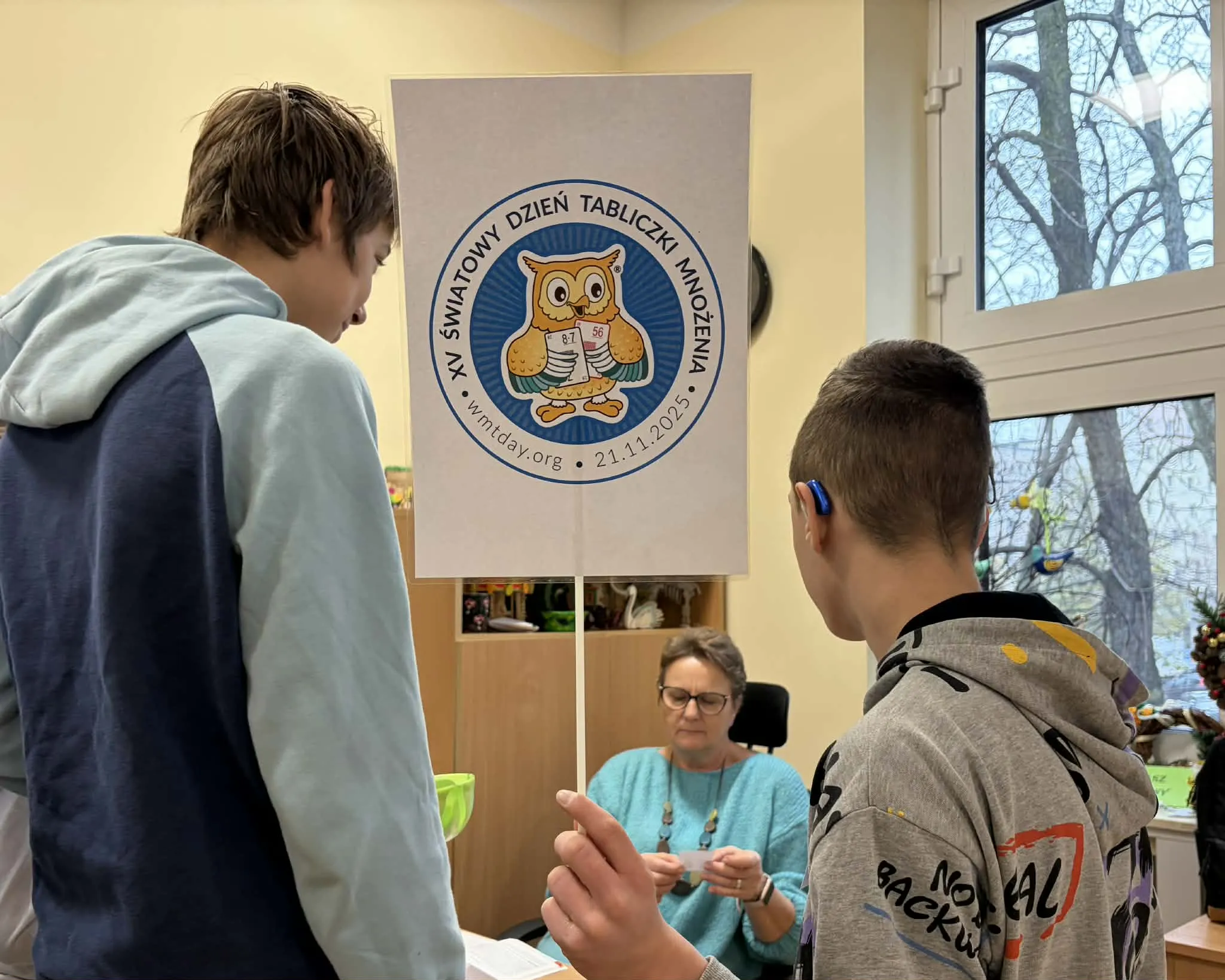 Delegacja uczniów sprawdzająca znajomość tabliczki uczniów wśród pracowników szkoły