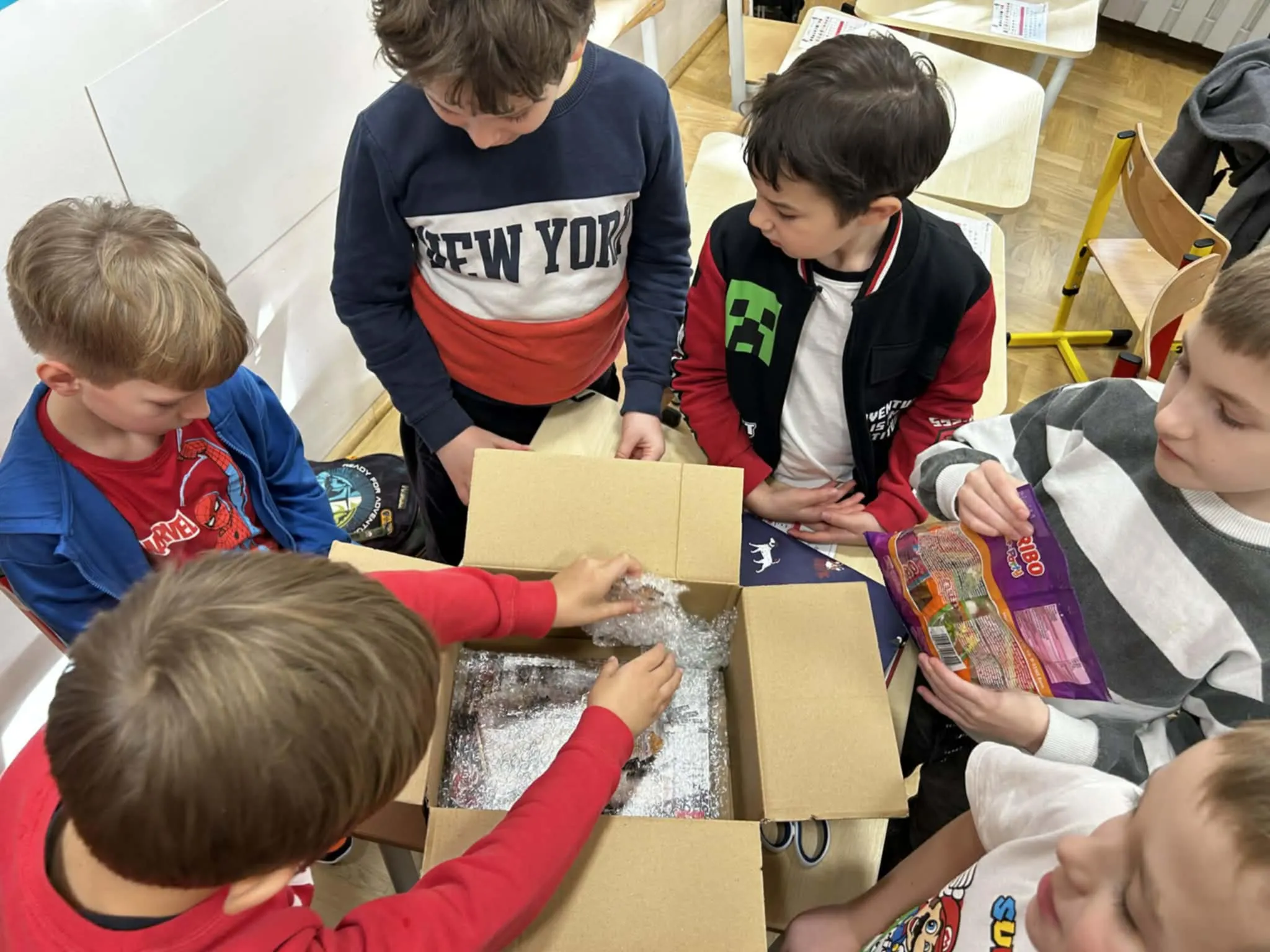 Uczniowie pakujący prezent