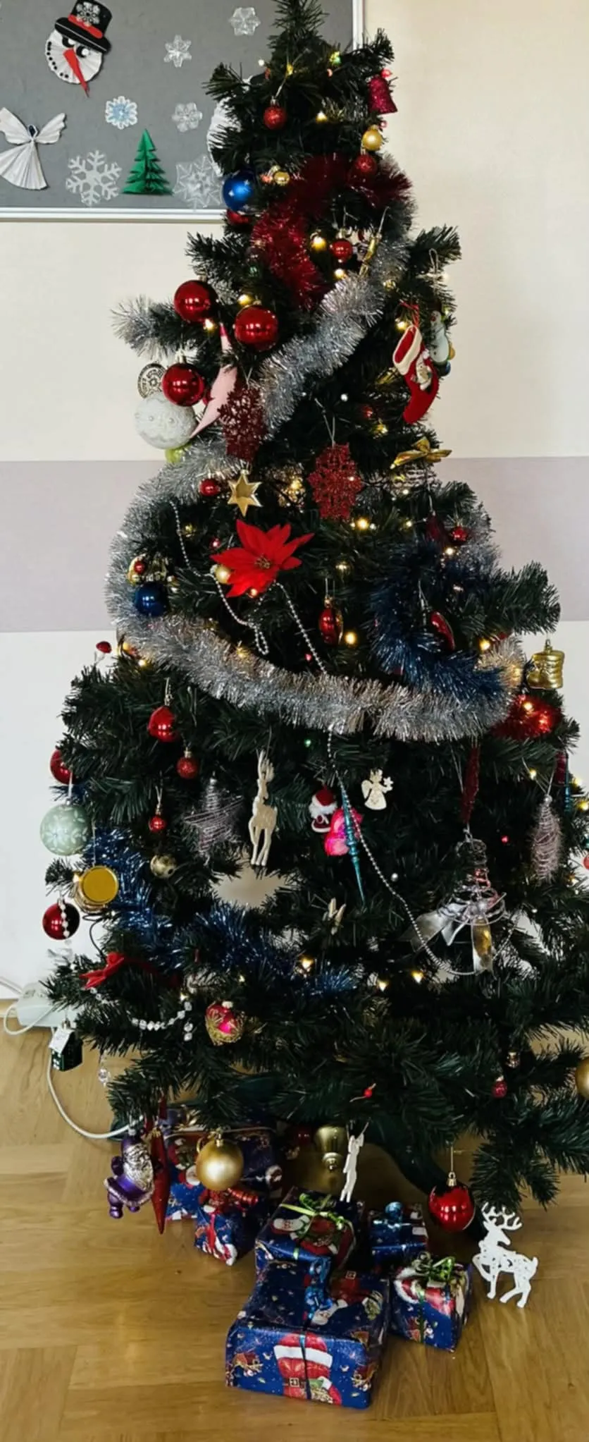 Ubrana choinka z prezentami pod spodem.