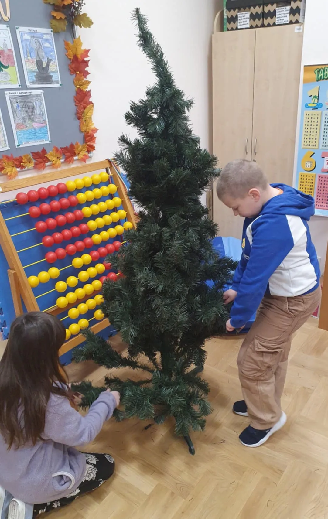 Uczniowie ubierający choinkę