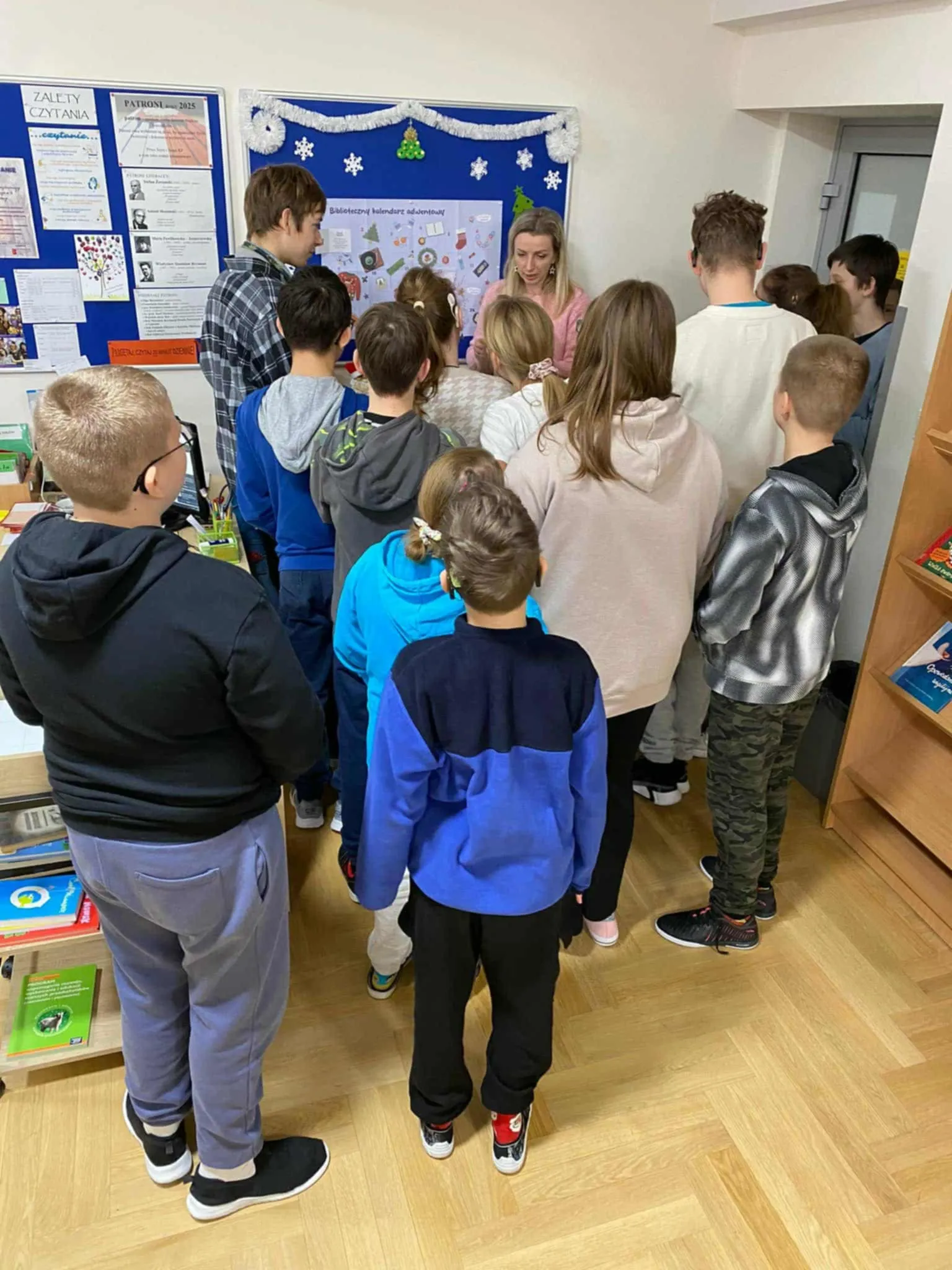 Uczniowie otwierający okienko w kalendarzu adwentowym 