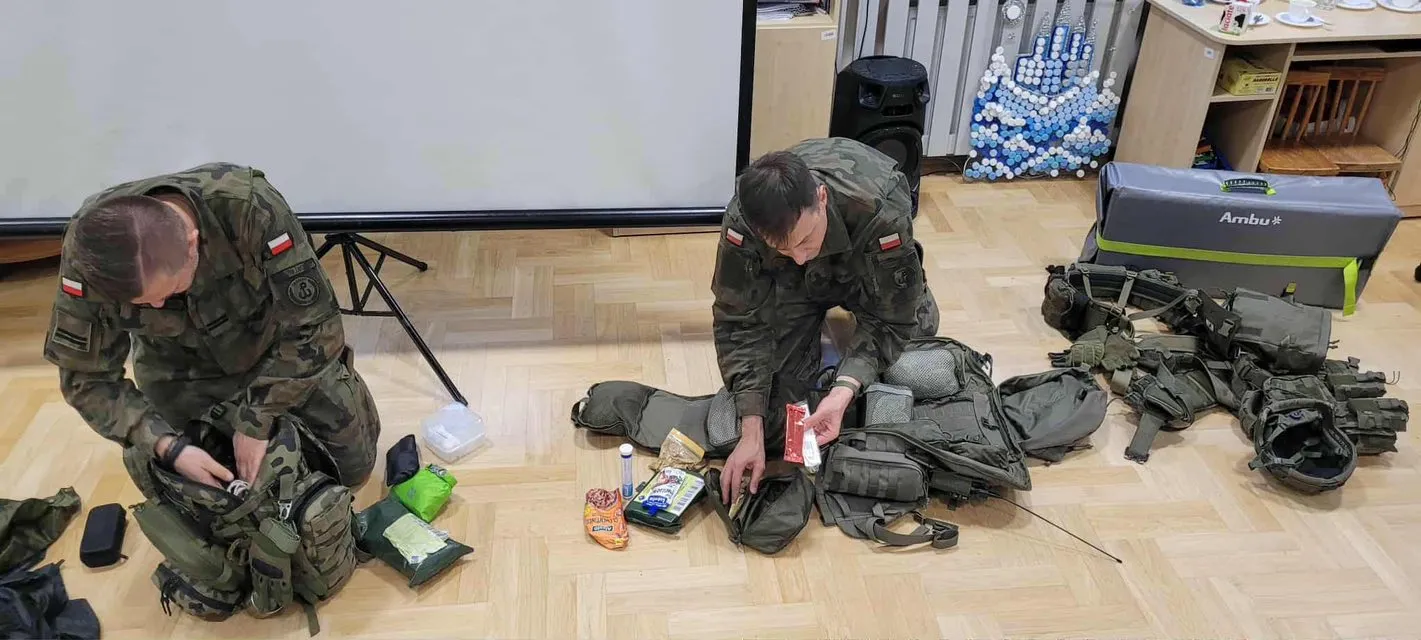 Żołnierze prezentujący sprzęt wojskowy przed uczniami 