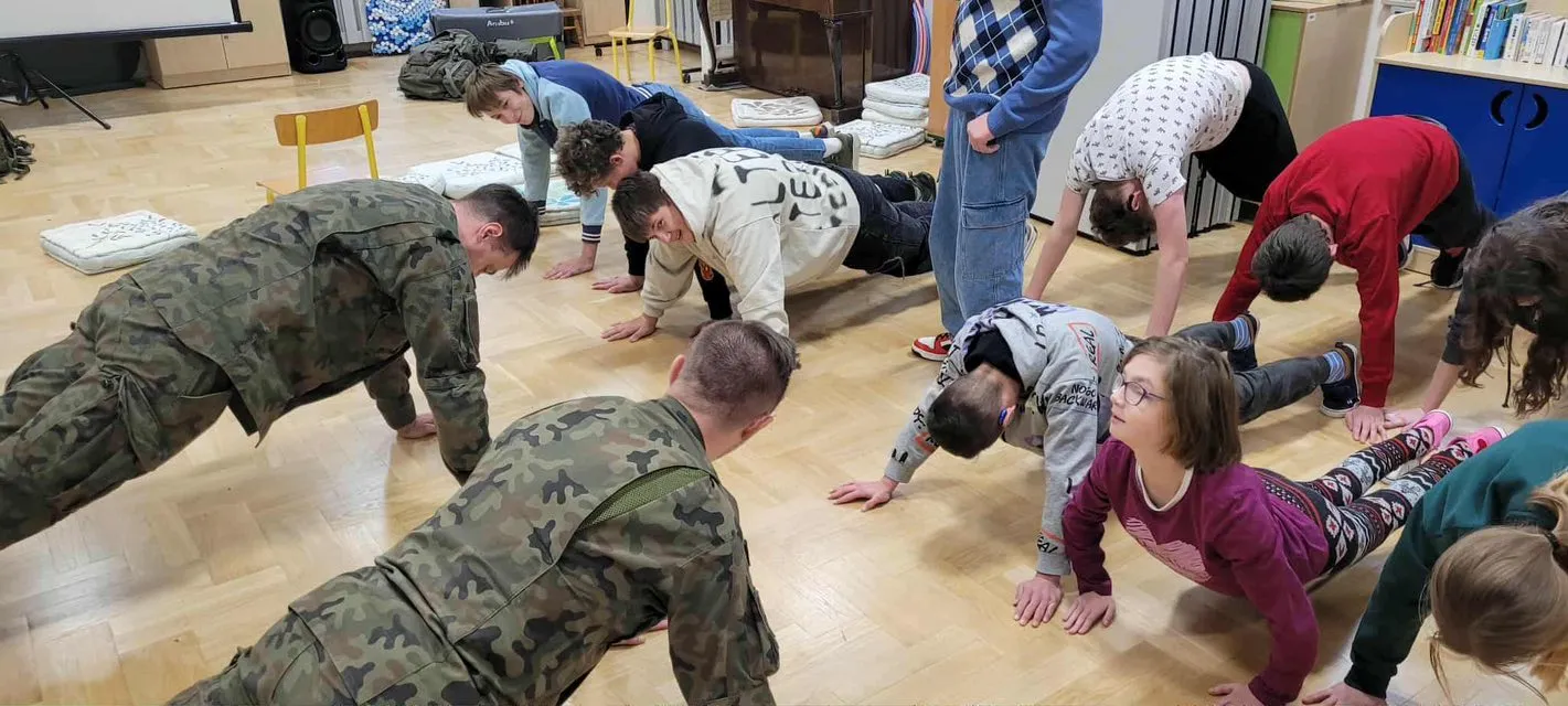 Uczniowie wraz z żołnierzami wykonują wspólne ćwiczenia