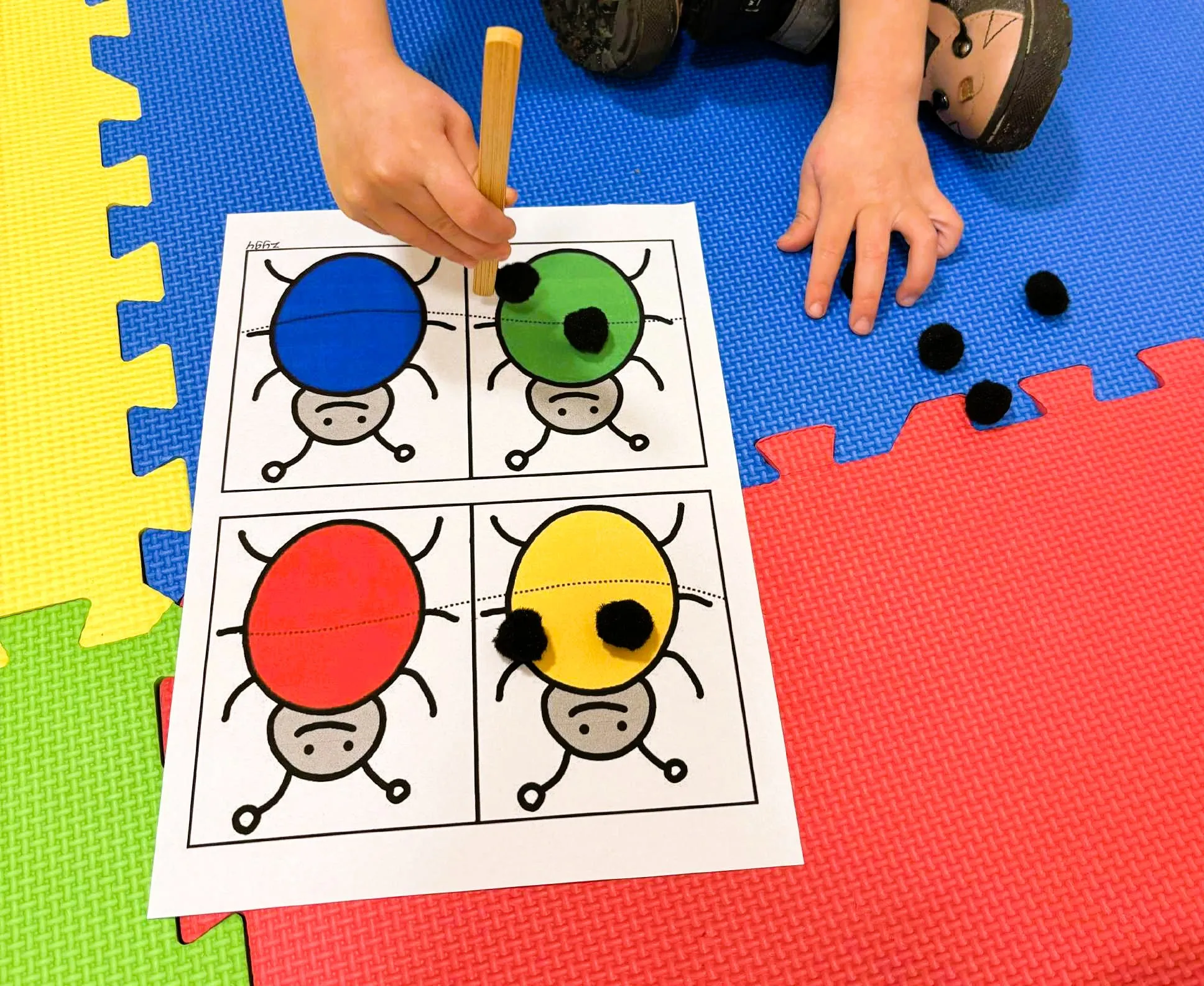 Uczeń siedzący na macie podczas zajęć z terapii pedagogicznej