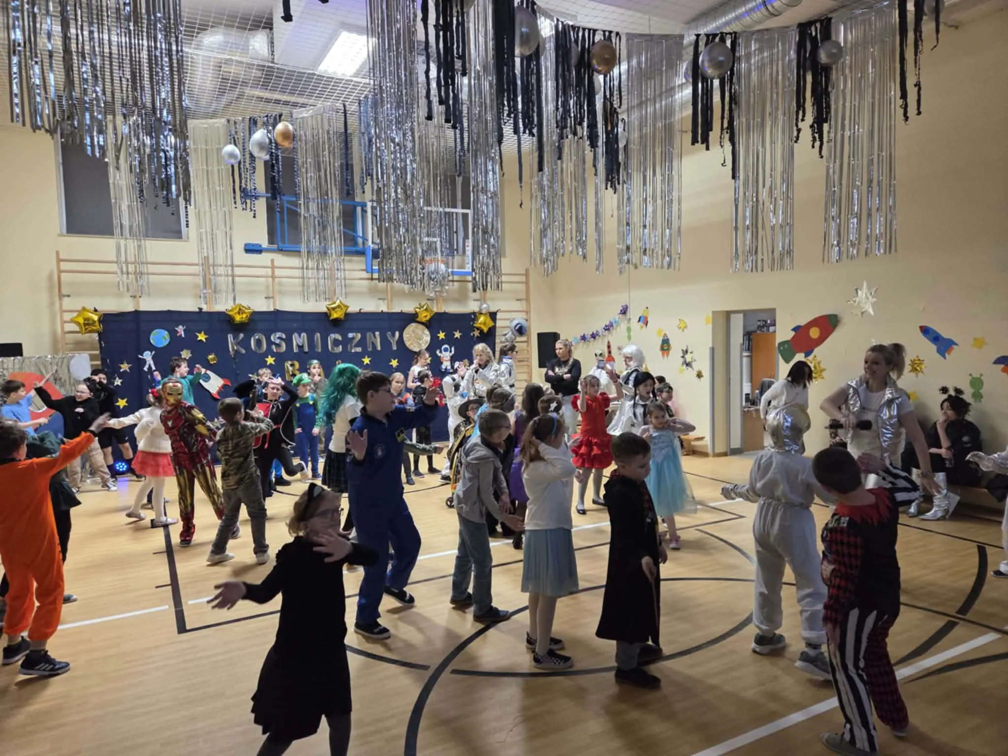 Uczniowie podczas balu karnawałowego na sali gimnastycznej