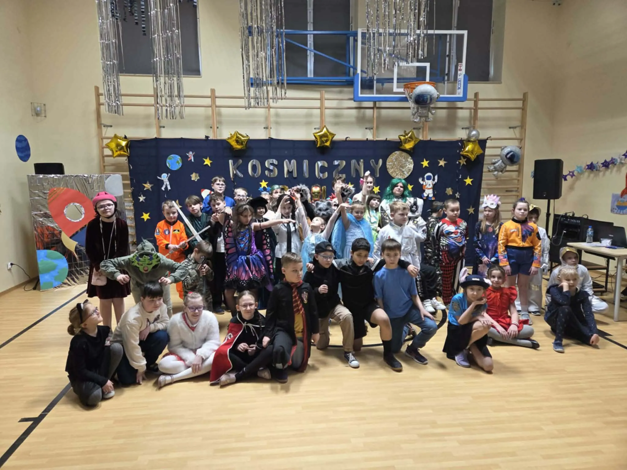 Uczniowie podczas balu karnawałowego na sali gimnastycznej