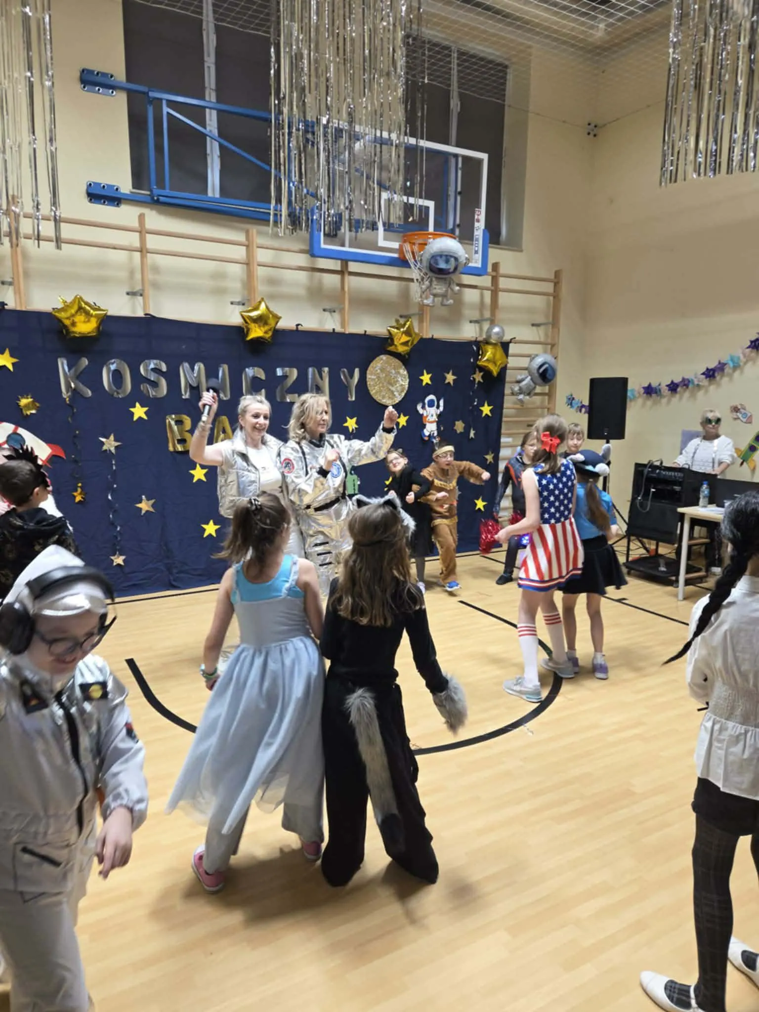 Uczniowie podczas balu karnawałowego na sali gimnastycznej