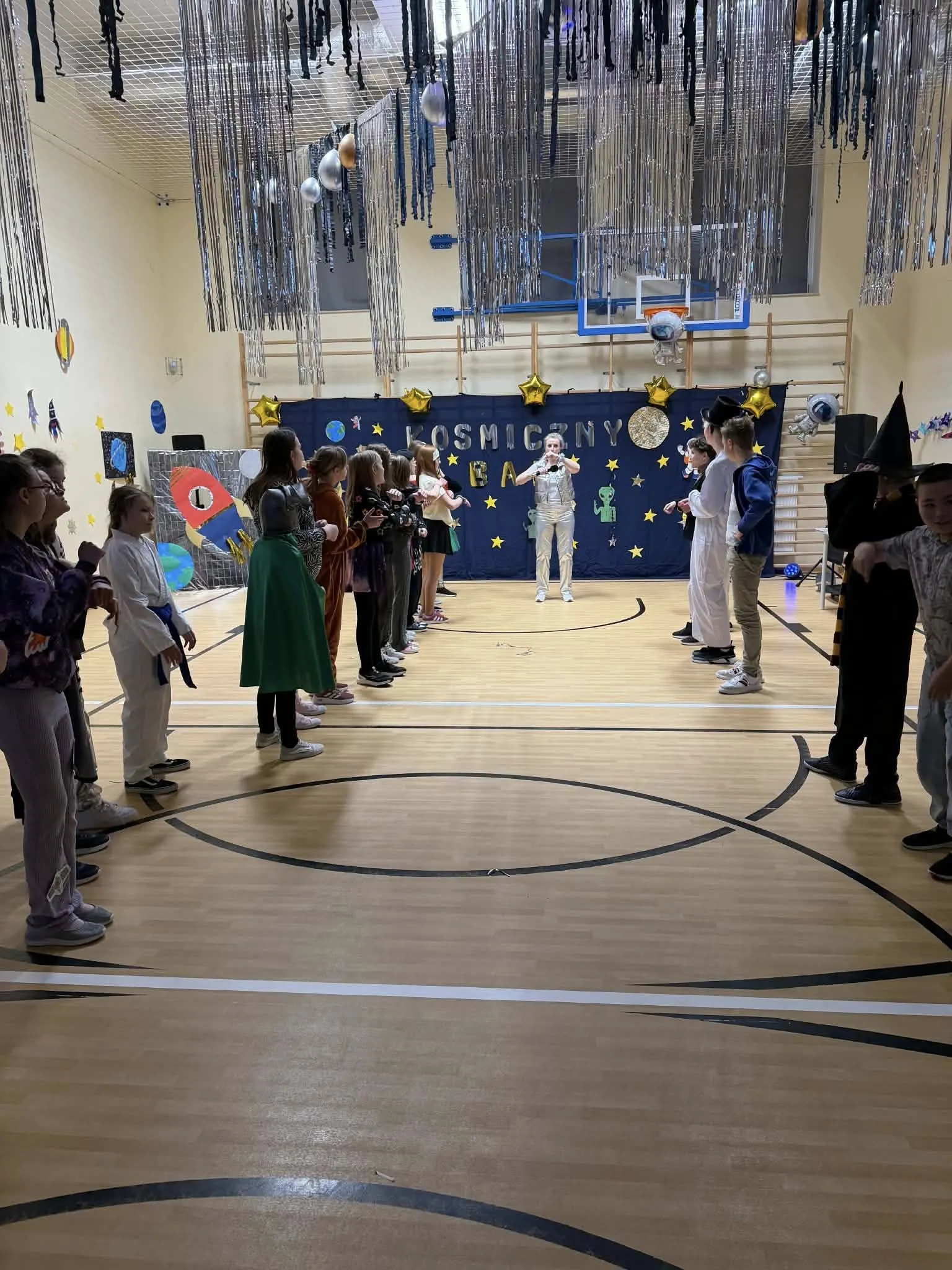 Uczniowie podczas balu karnawałowego na sali gimnastycznej