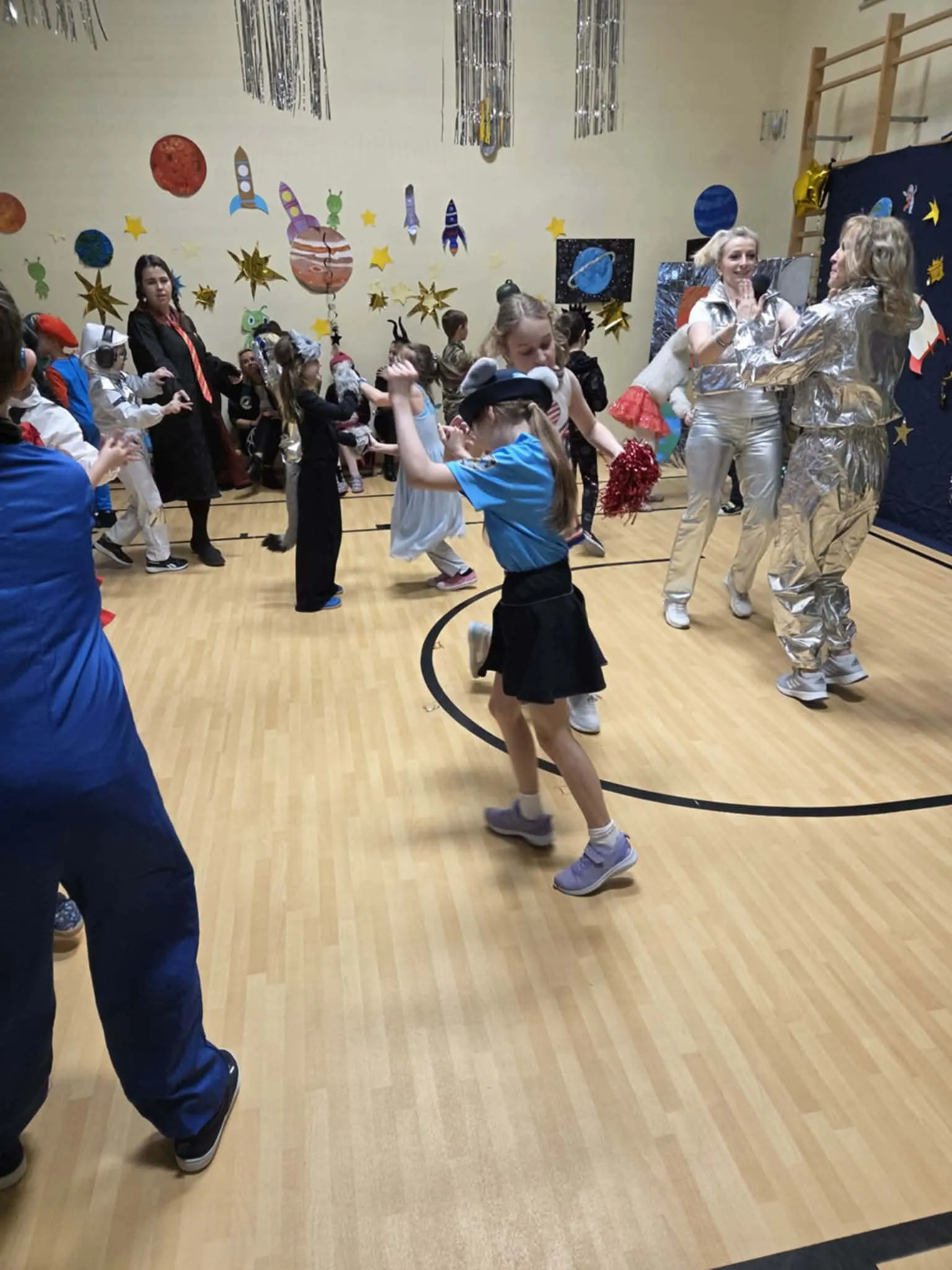 Uczniowie podczas balu karnawałowego na sali gimnastycznej