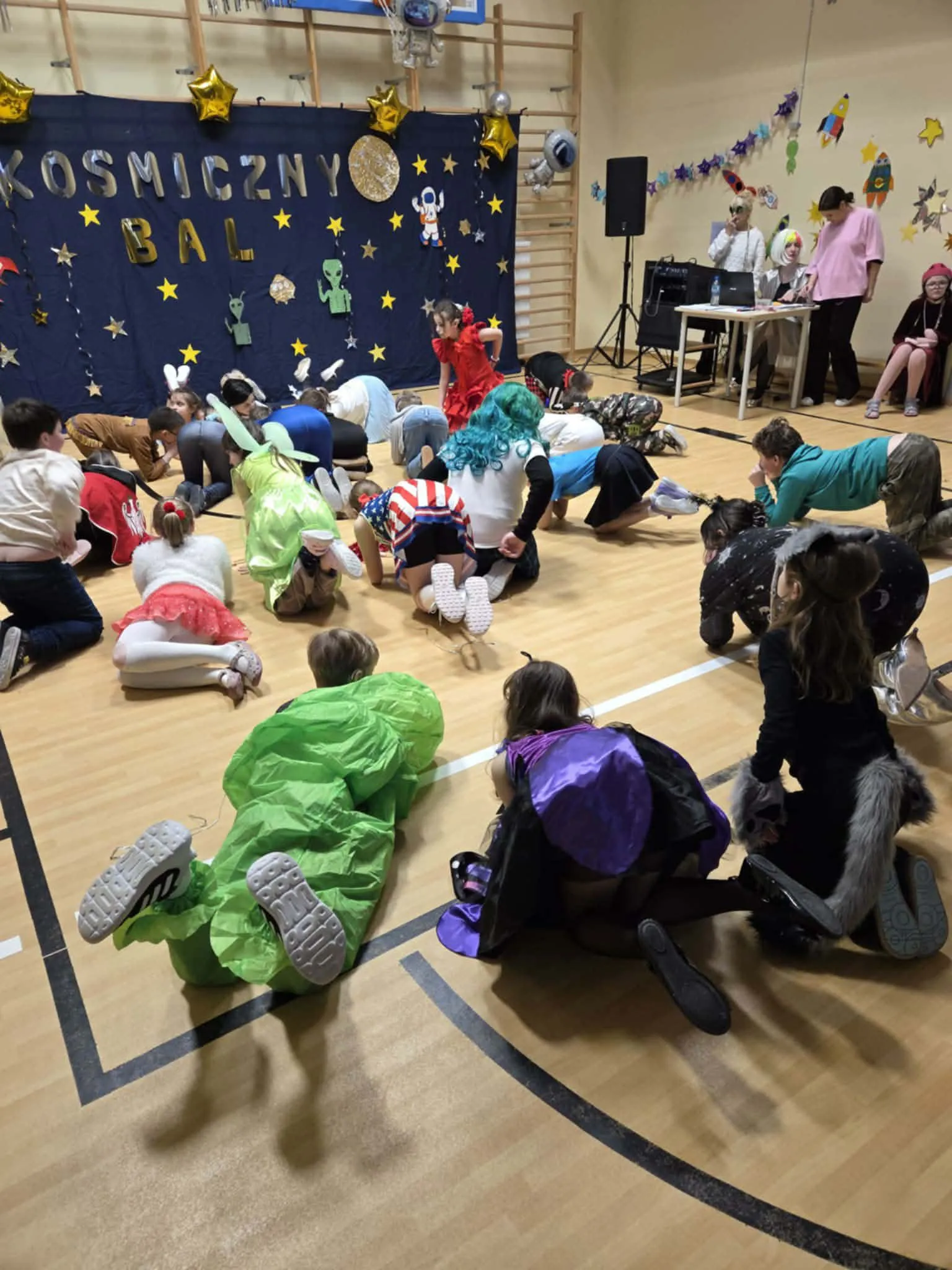 Uczniowie podczas balu karnawałowego na sali gimnastycznej