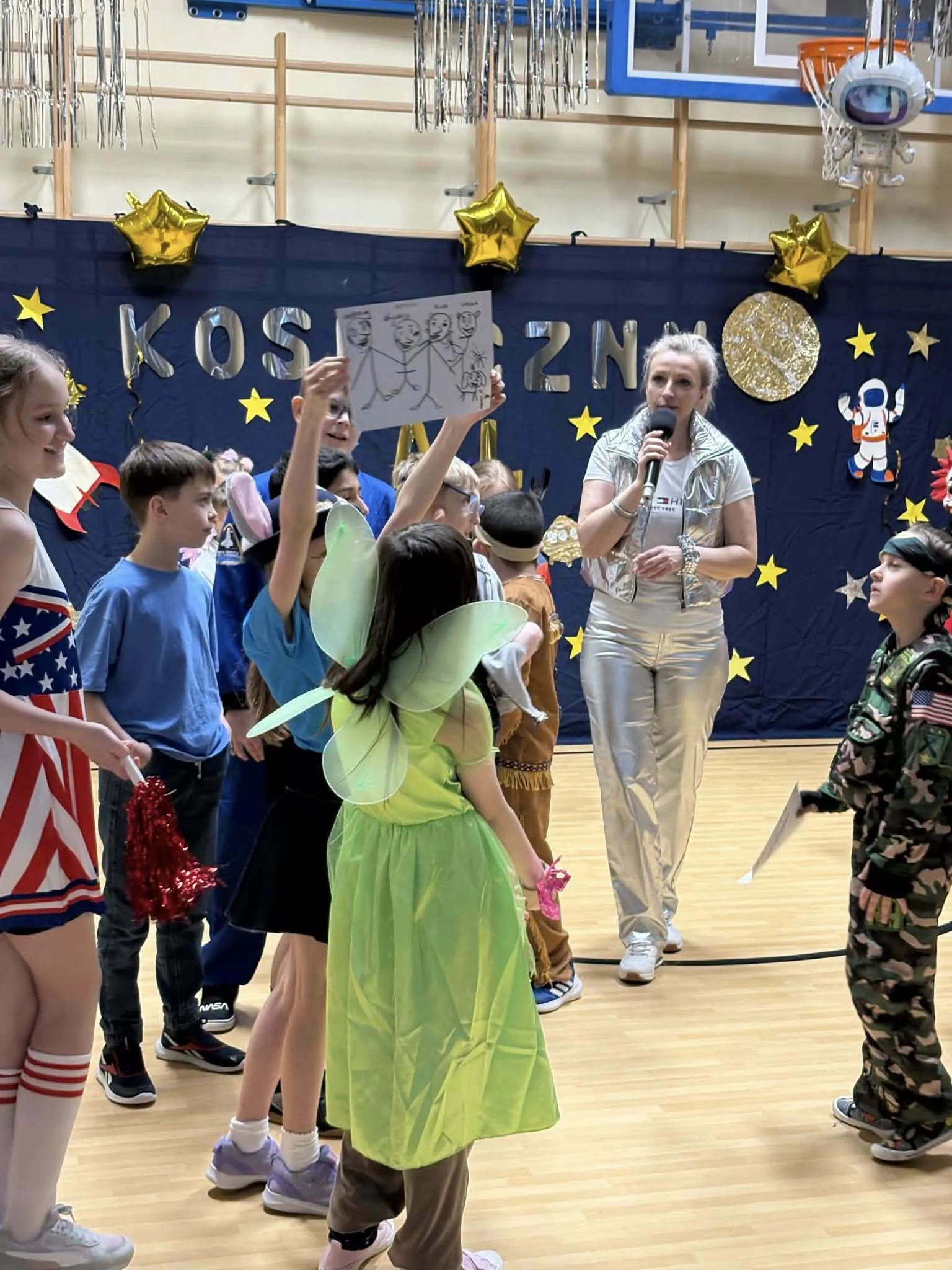 Uczniowie podczas balu karnawałowego na sali gimnastycznej