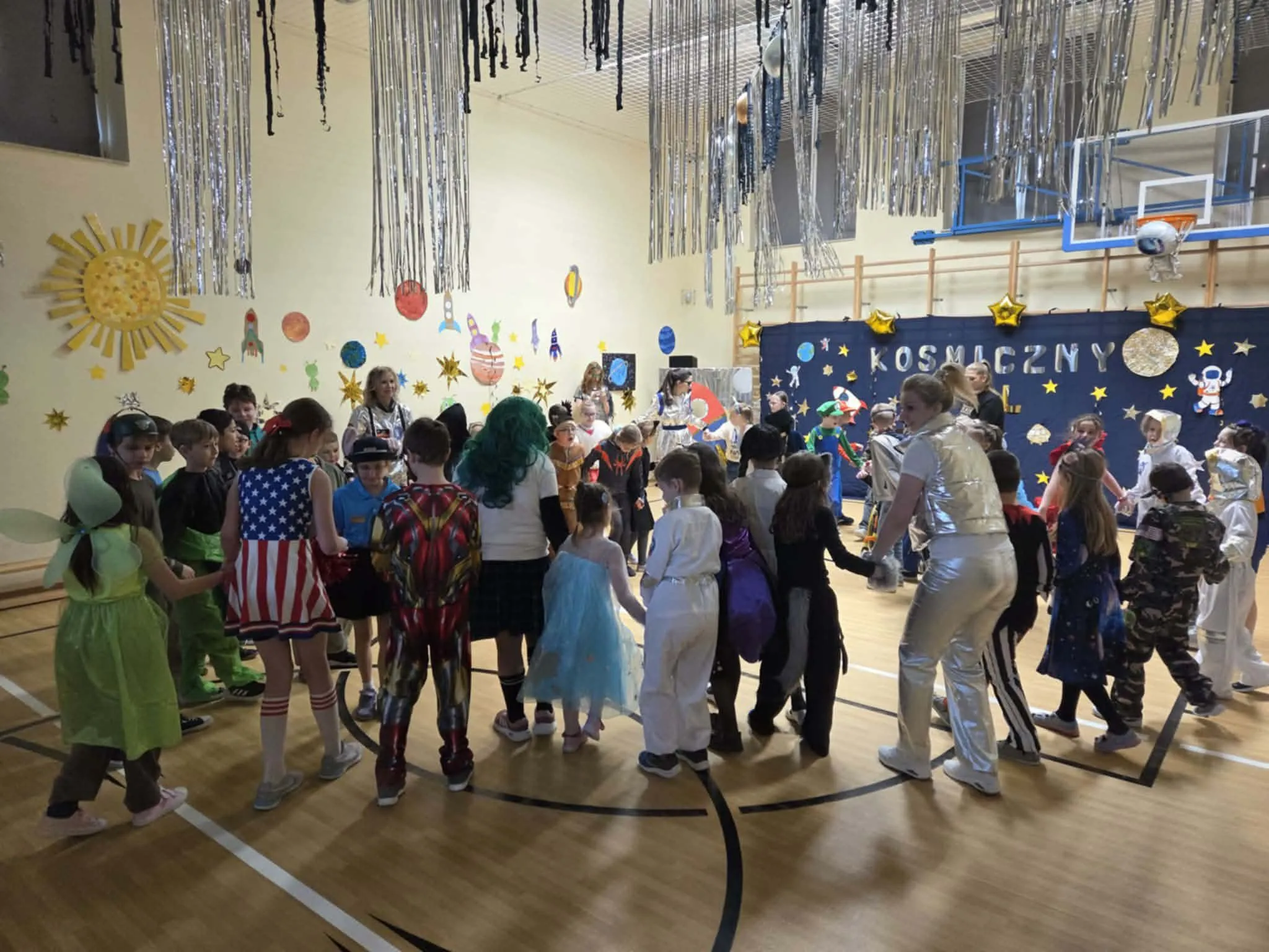 Uczniowie podczas balu karnawałowego na sali gimnastycznej