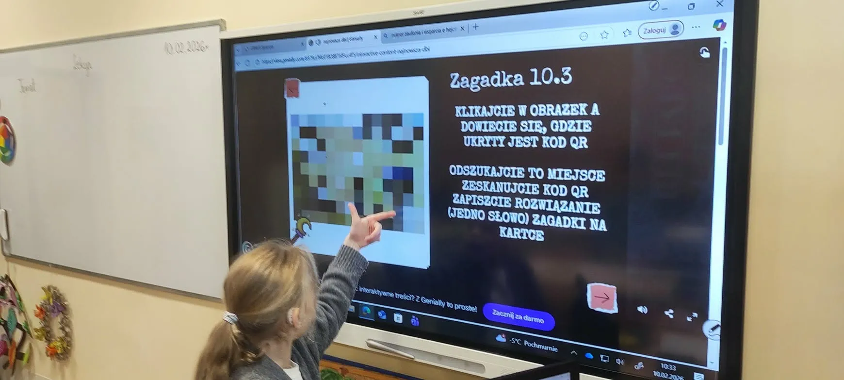 uczniowie stoją przed tablicą interaktywną i rozwiązują zadania
