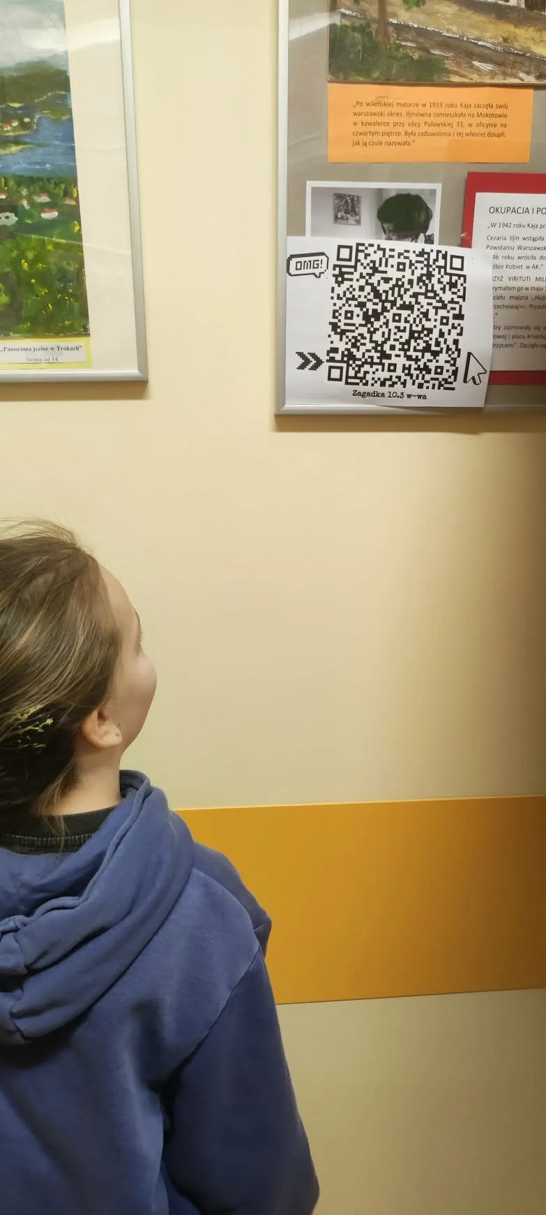 uczennica patrzy  na kod QR umieszczony na tablicy