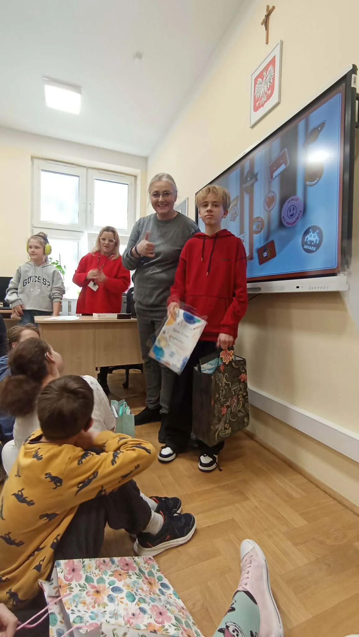 uczeń z nauczycielami nagrodzony w konkursie plastycznym