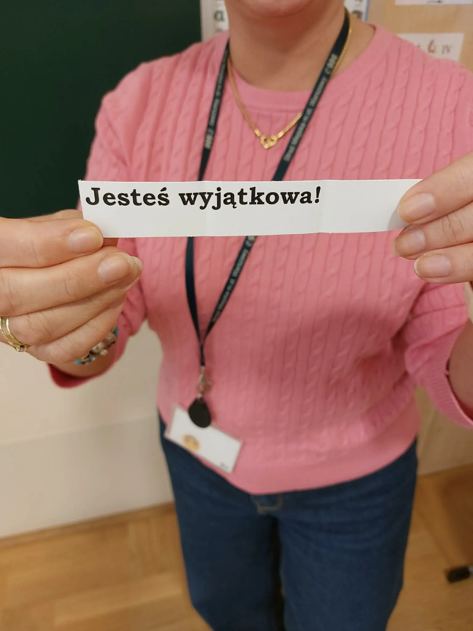 Kobieta trzyma kartkę z napisem „Jesteś wyjątkowa!” przygotowaną z okazji Dnia Kobiet.