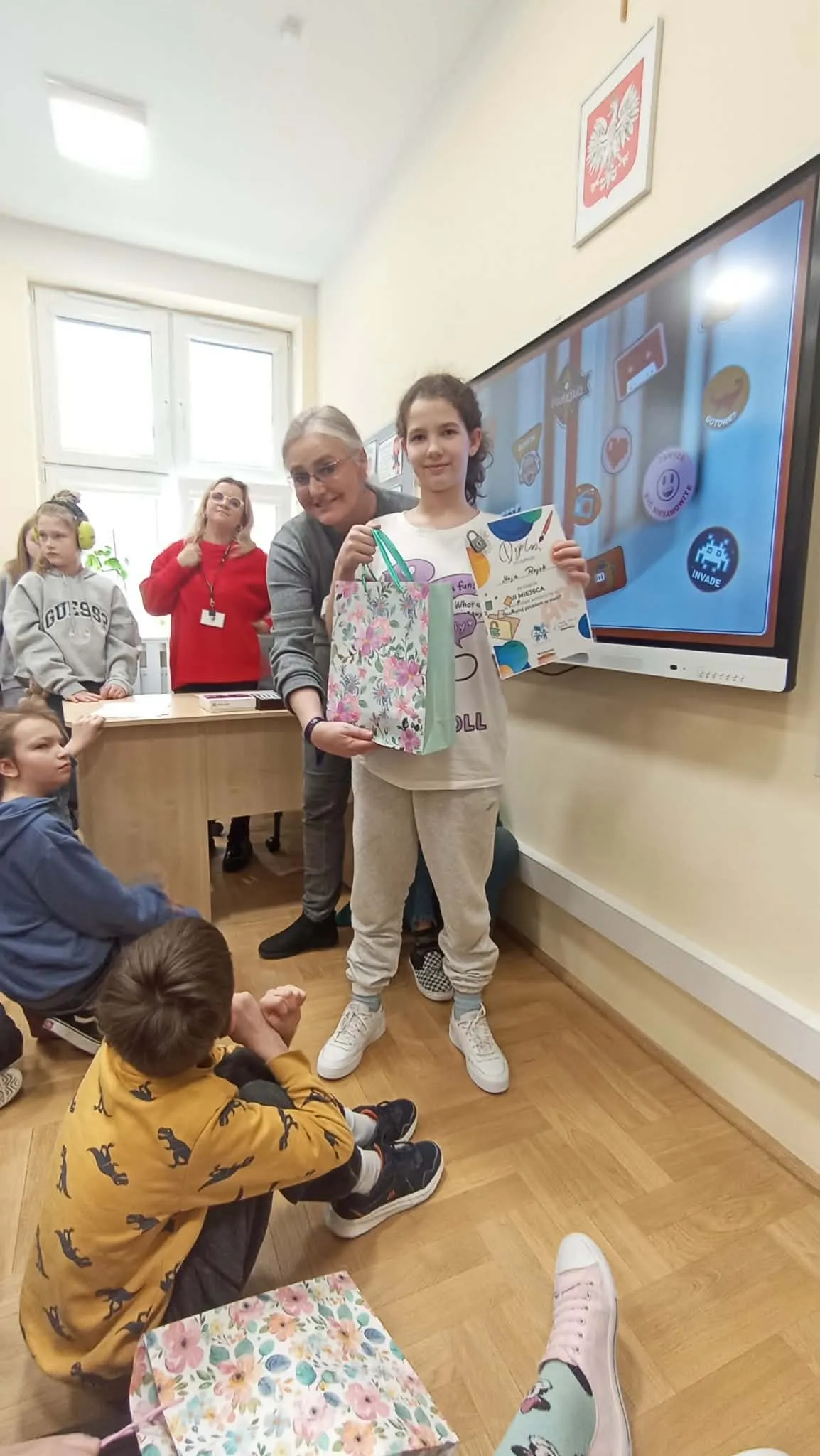 uczennica z nauczycielami nagrodzona w konkursie plastycznym