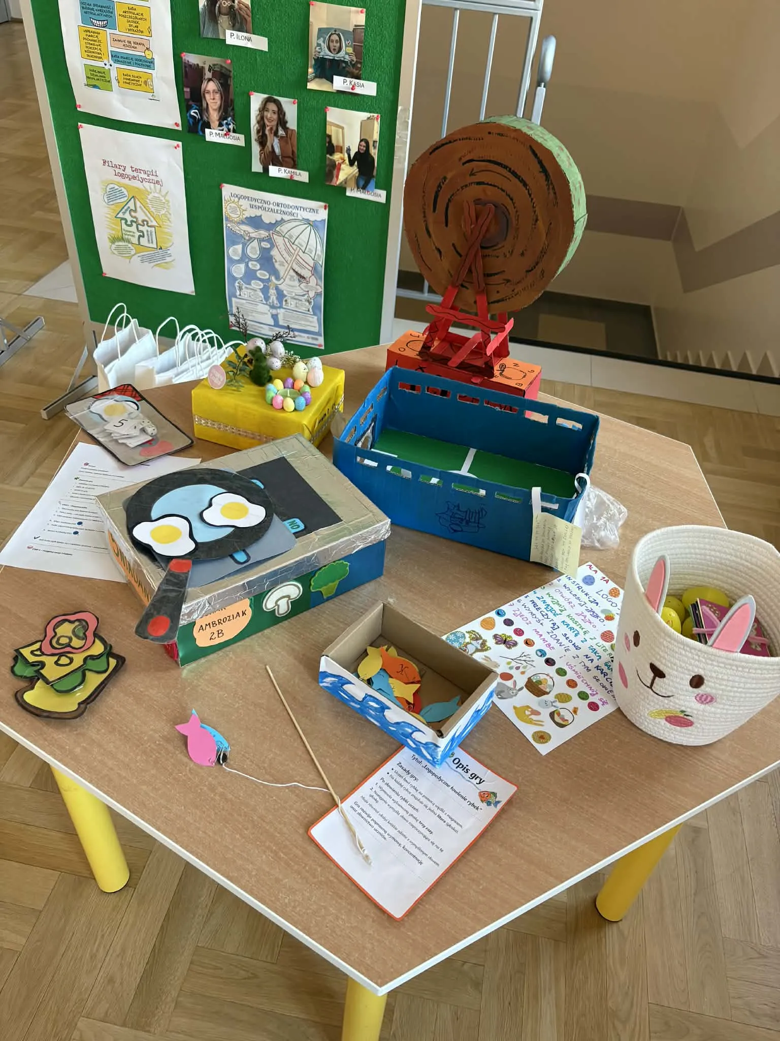 Kolorowe, ręcznie wykonane pomoce logopedyczne i gry edukacyjne ułożone na stole