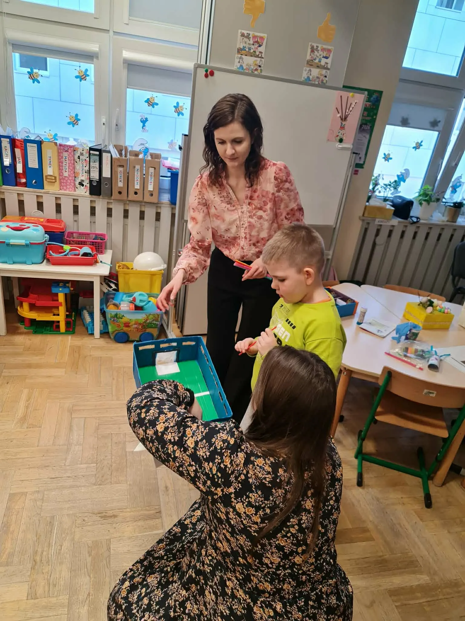 Nauczycielki pomagają dziecku w zabawie edukacyjnej z wykorzystaniem gry logopedycznej