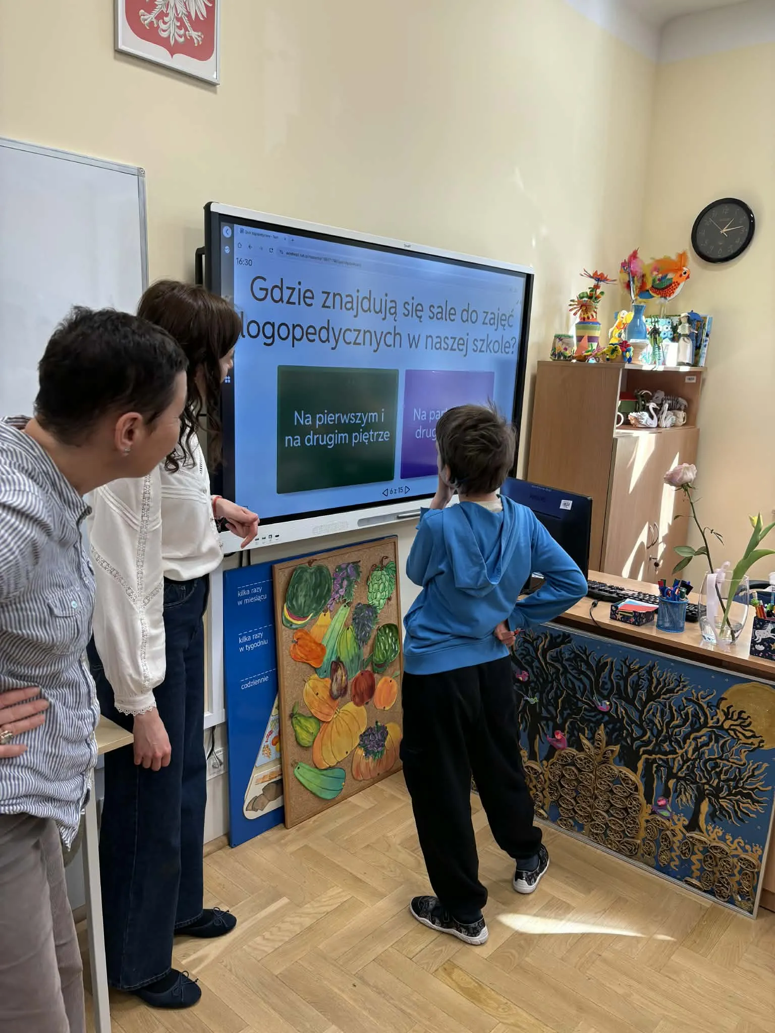 Dziecko odpowiada na pytanie na ekranie interaktywnym podczas zajęć w klasie