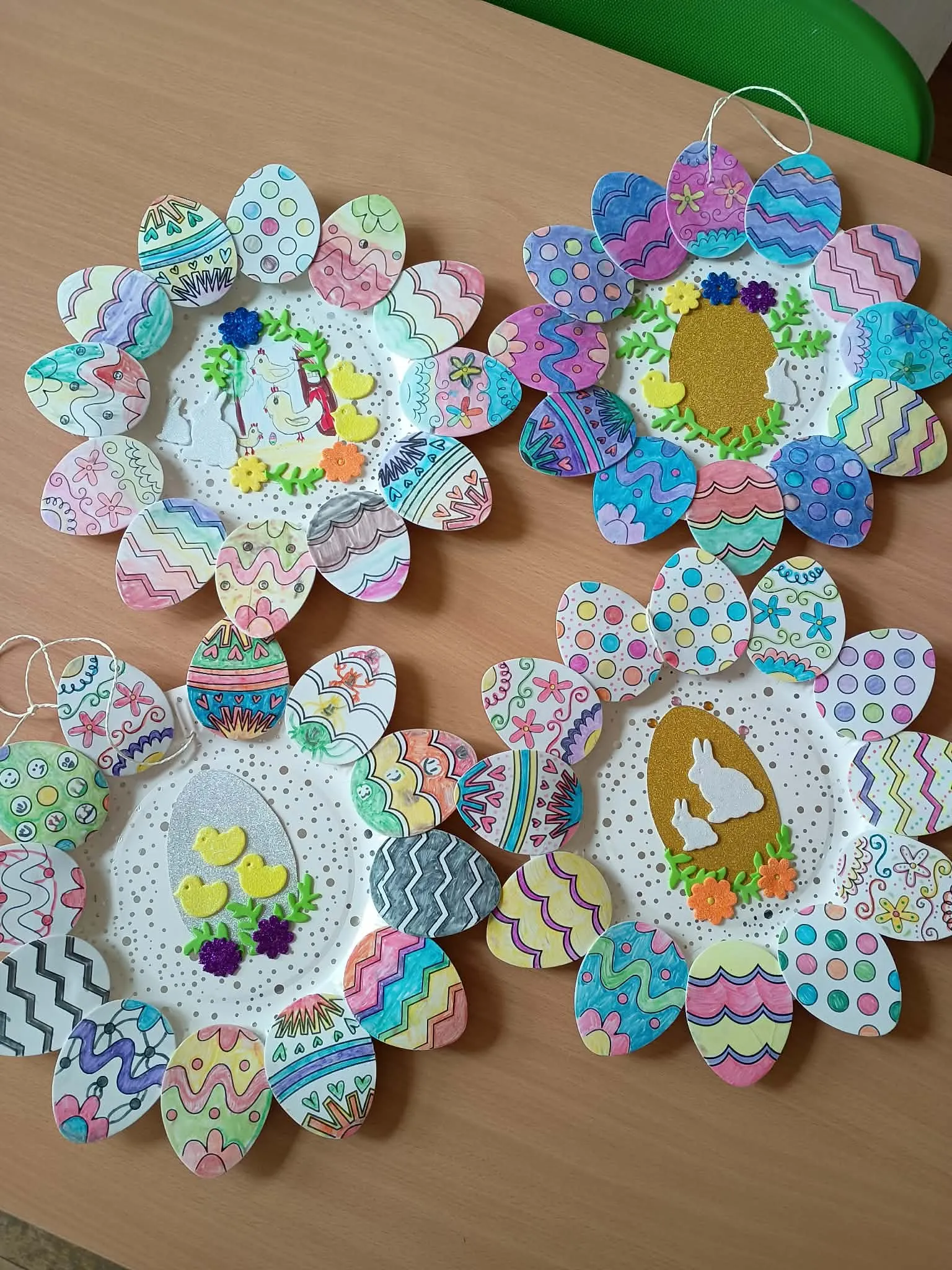 Kolorowe ozdoby wielkanocne wykonane z papierowych talerzyków i dekoracyjnych jajek