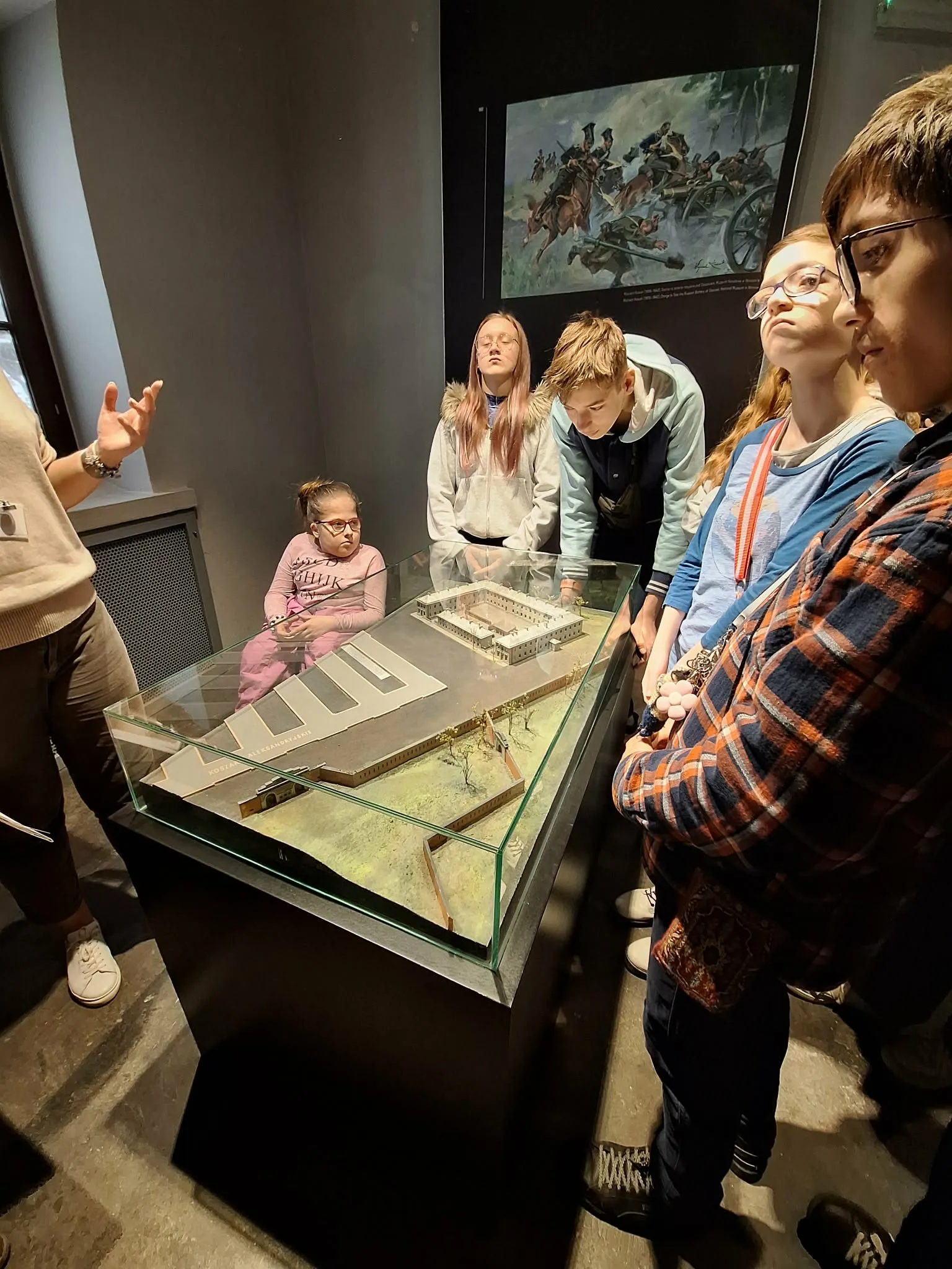 Uczniowie oglądają makietę historycznego budynku podczas oprowadzania po muzeum