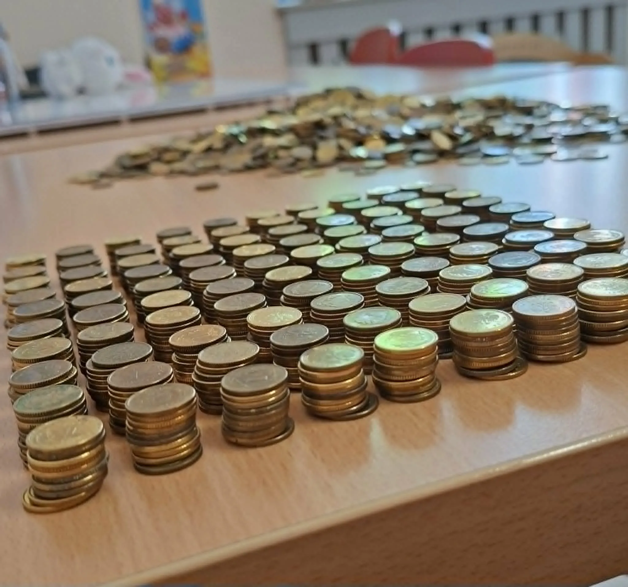 Ułożone w stosy monety o różnych nominałach przygotowywane do przekazania w akcji Góra Grosza.
