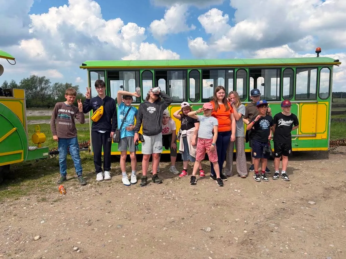 Grupowe zdjęcie uczniów na tle kolejki