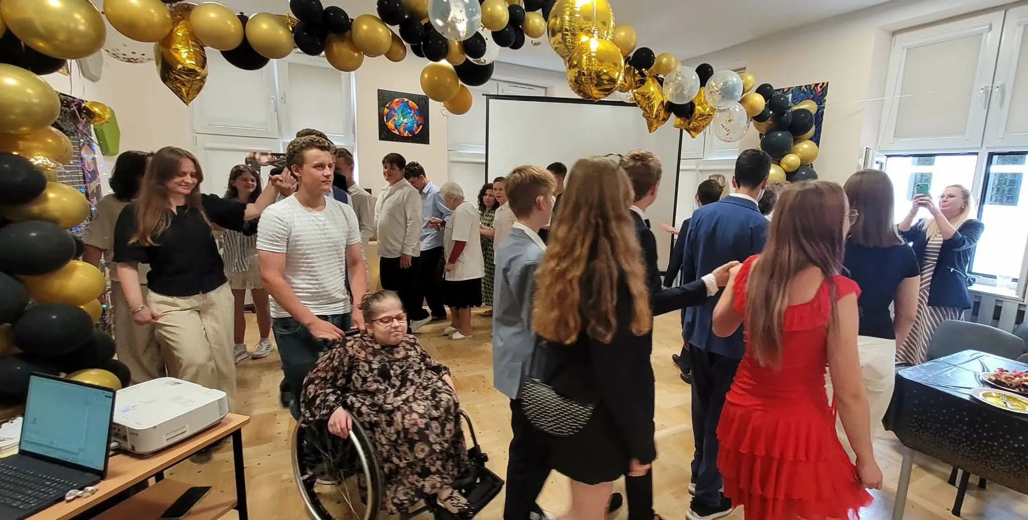 bal ósmoklasisty - uczniowie tańczą z nauczycielami poloneza