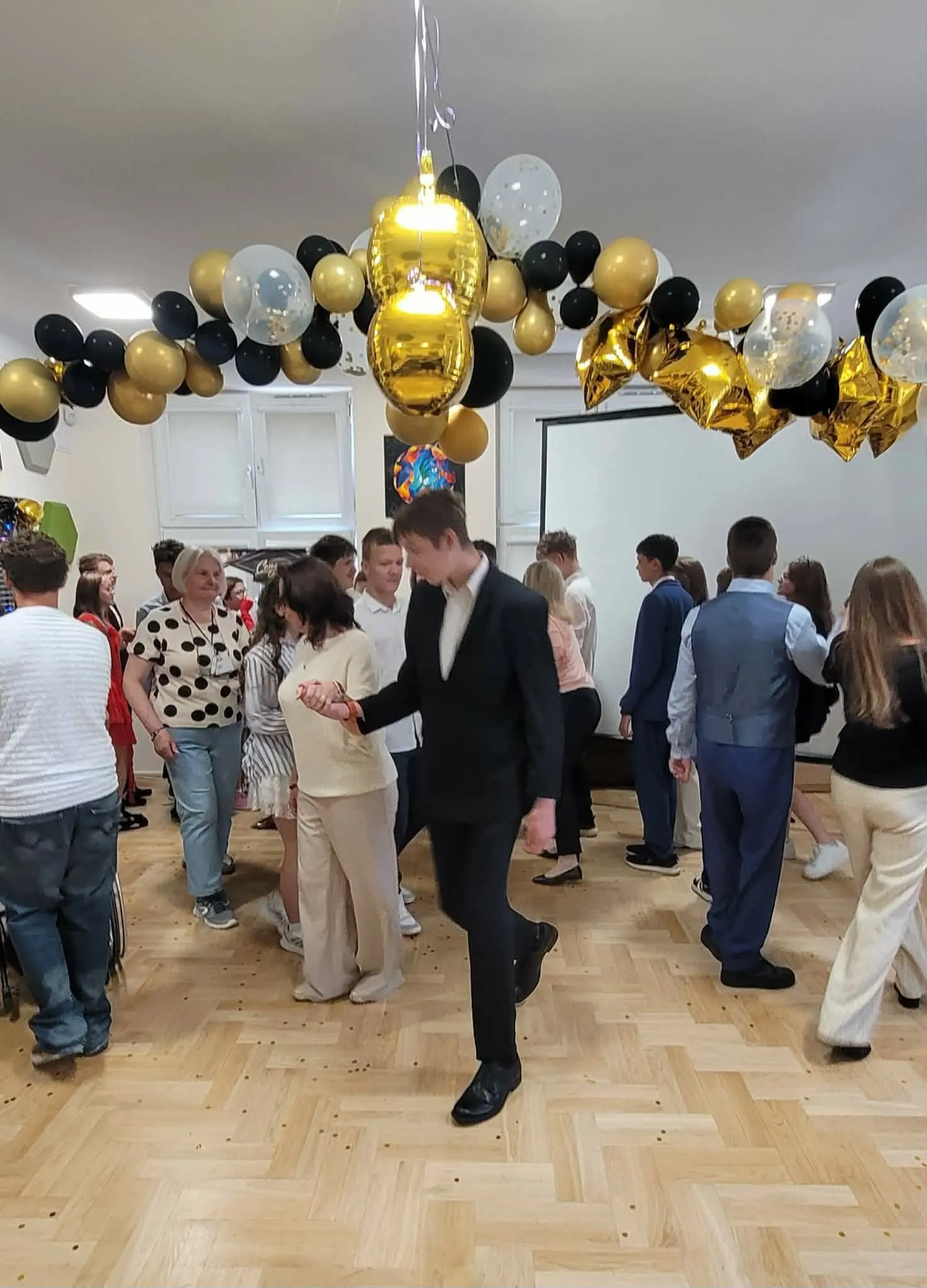 bal ósmoklasisty - uczniowie tańczą z nauczycielami poloneza
