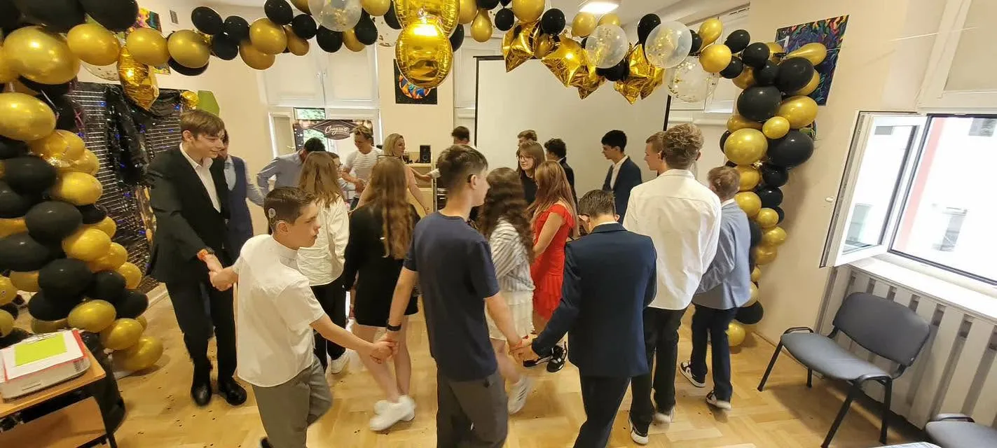 bal ósmoklasisty - uczniowie tańczą z nauczycielami poloneza