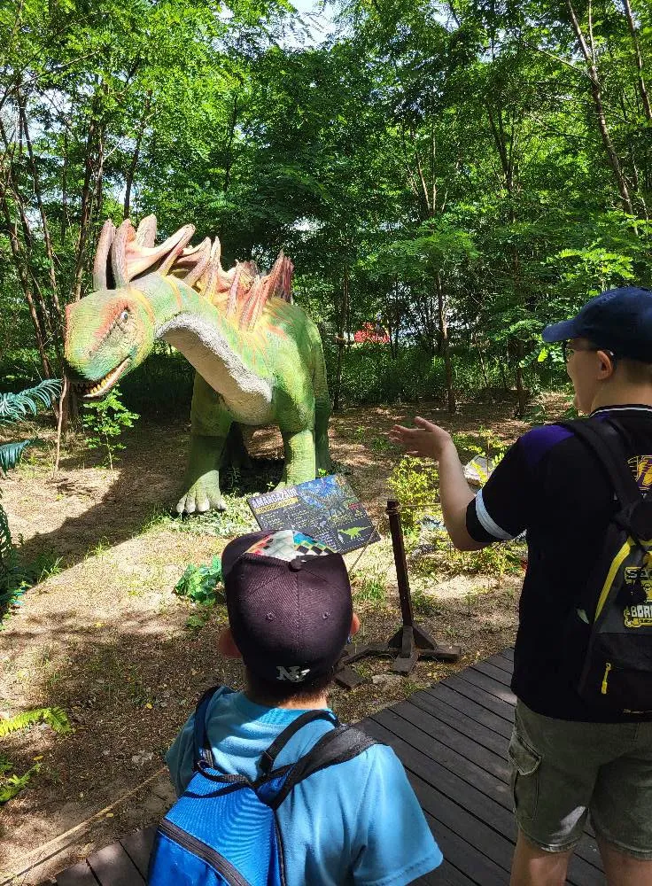 uczniowie podczas wycieczki w parku dinozaurów